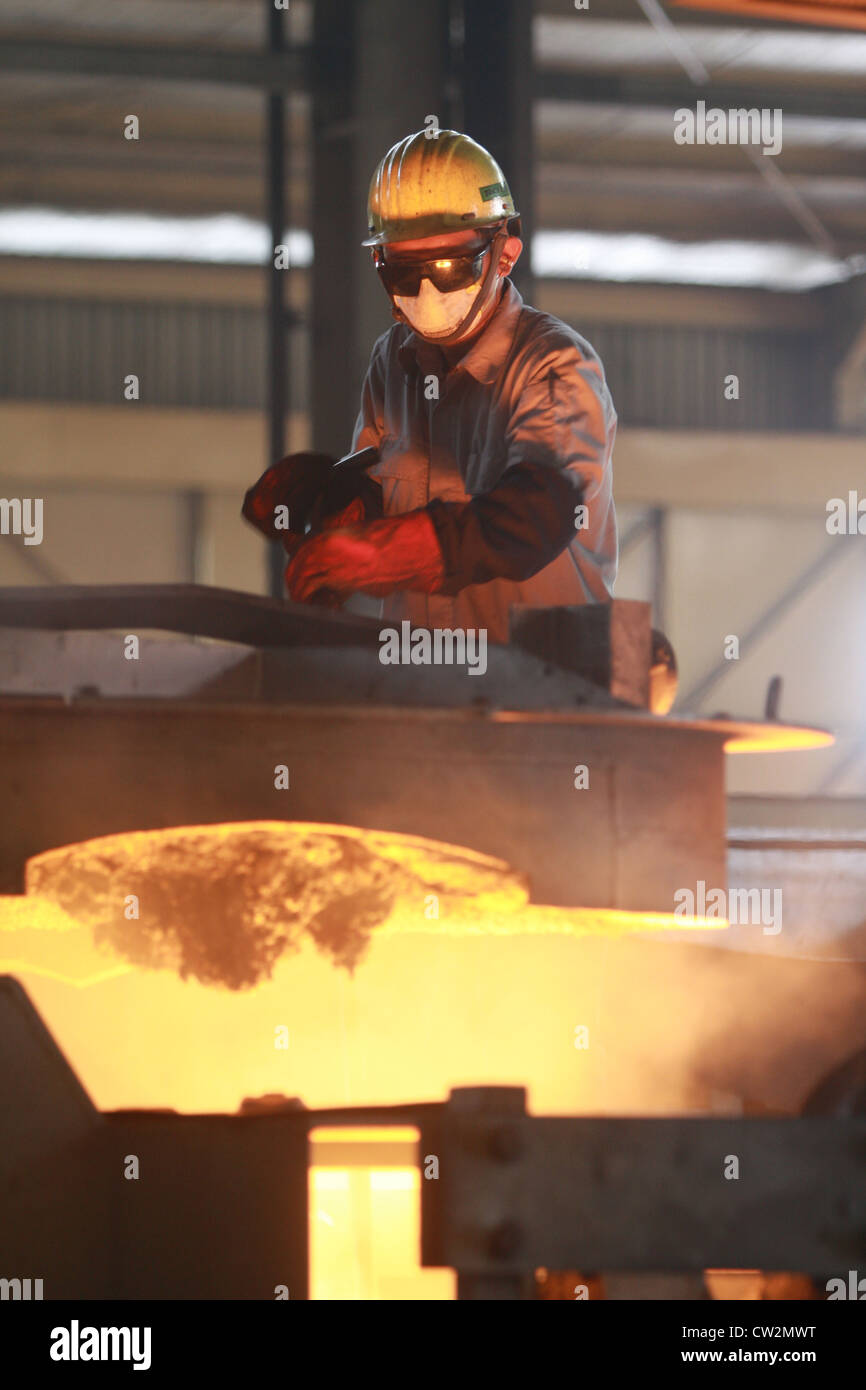 Ein Arbeiter Eisen Probenentnahme mit einer Lanze auf Gießerei Stockfoto