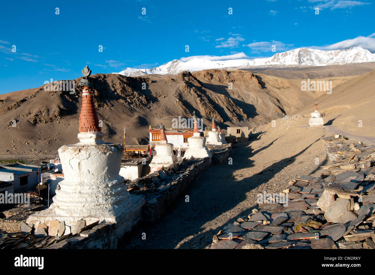 Linie von rot-Spitze Chörten gegen ein blauer Himmel und schneebedeckte Berge in hoch gelegenen Dorf von Korzok, Ladakh, Indien Stockfoto