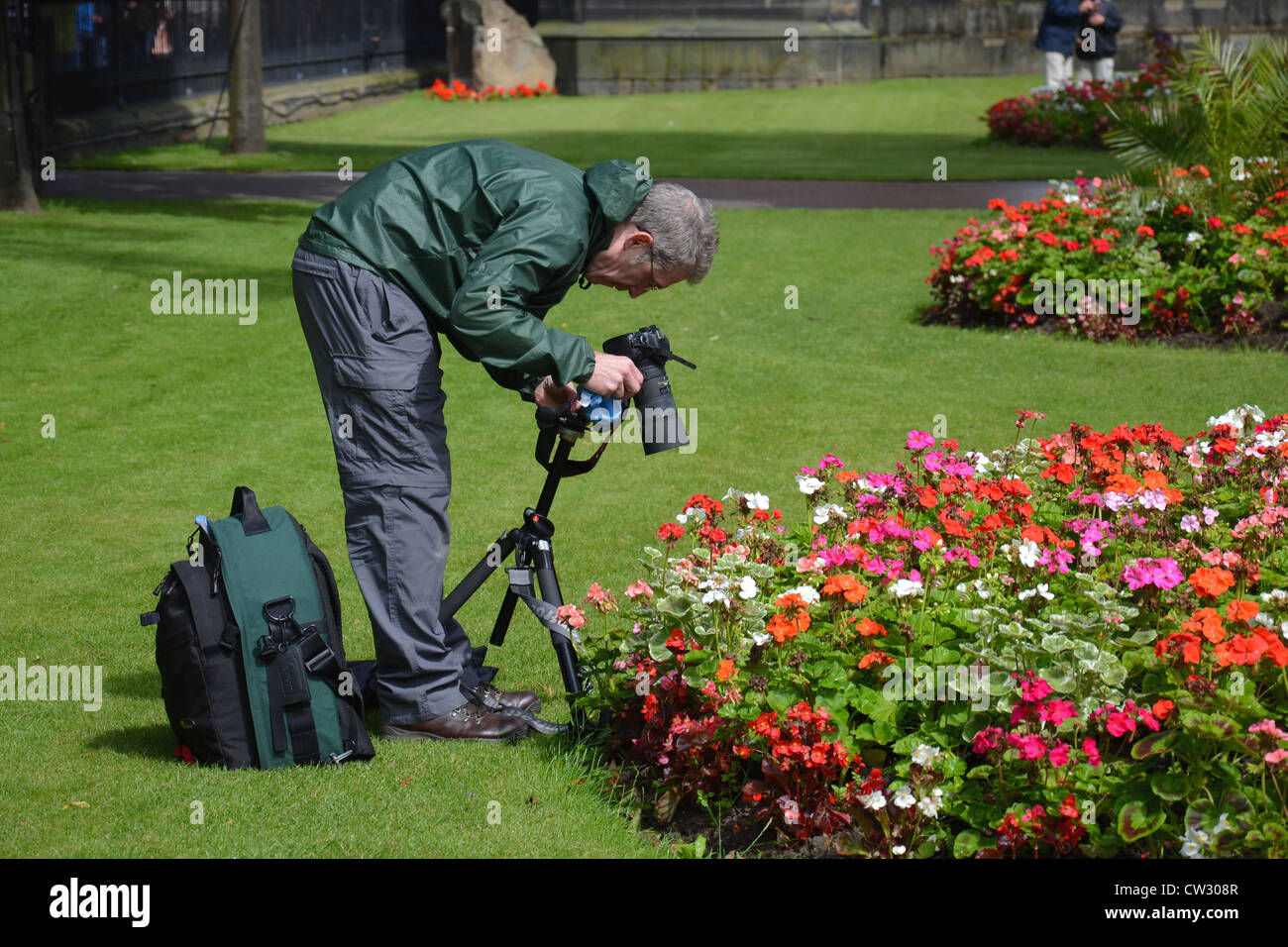 Fotograf mit Kamera fotografieren Blumen in den Princes Street Gardens, Edinburgh. Stockfoto