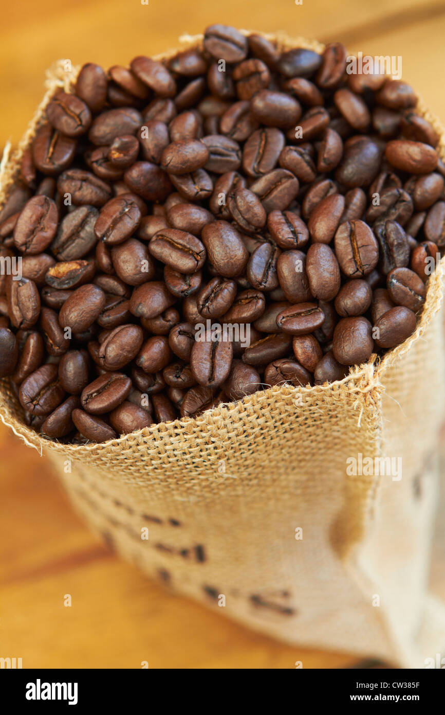 Draufsicht der Kaffeebohnen im Sack auf Holzboden Stockfoto
