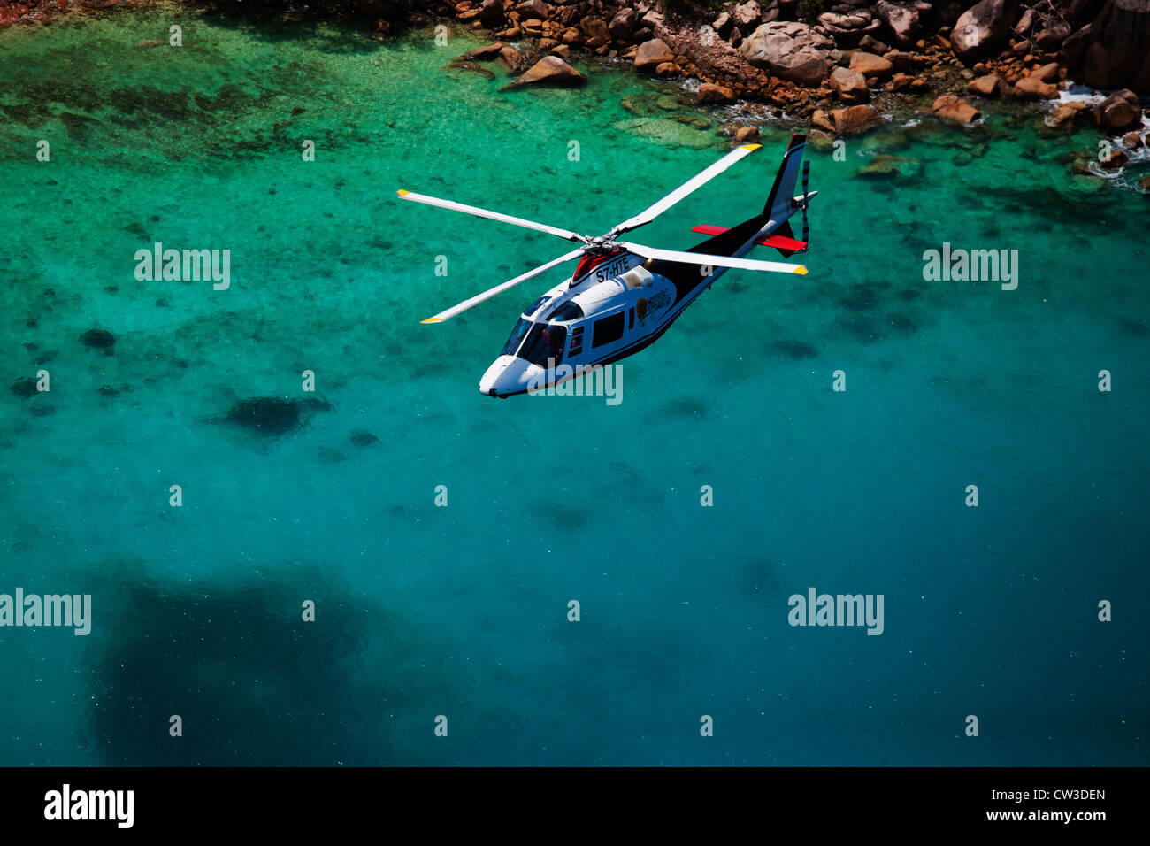 Agusta 109C Hubschrauber fliegen über der Küste Praslin.Seychelles Stockfoto