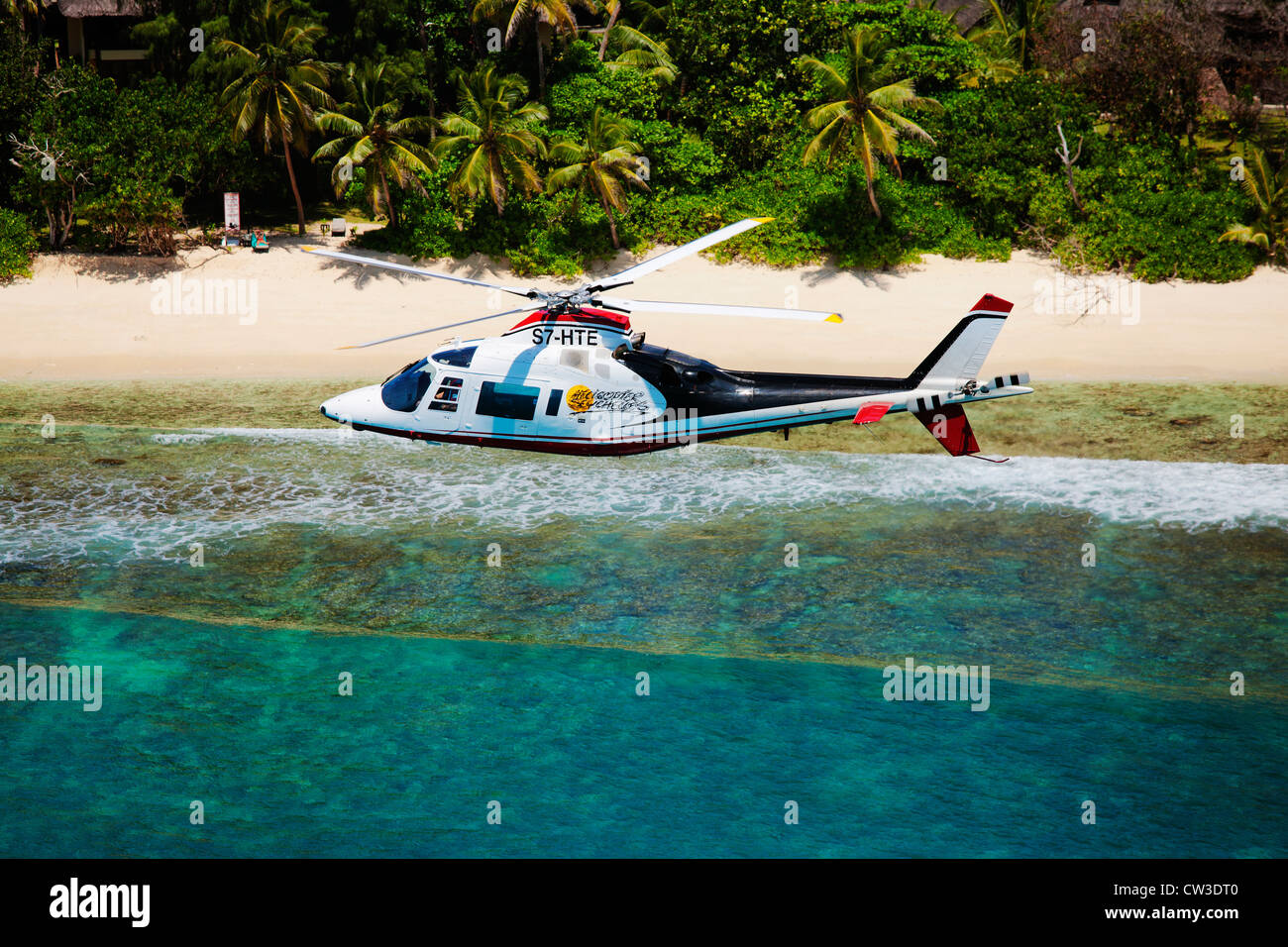 Agusta 109C Hubschrauber fliegen über die Küste Praslin.Seychelles. Stockfoto