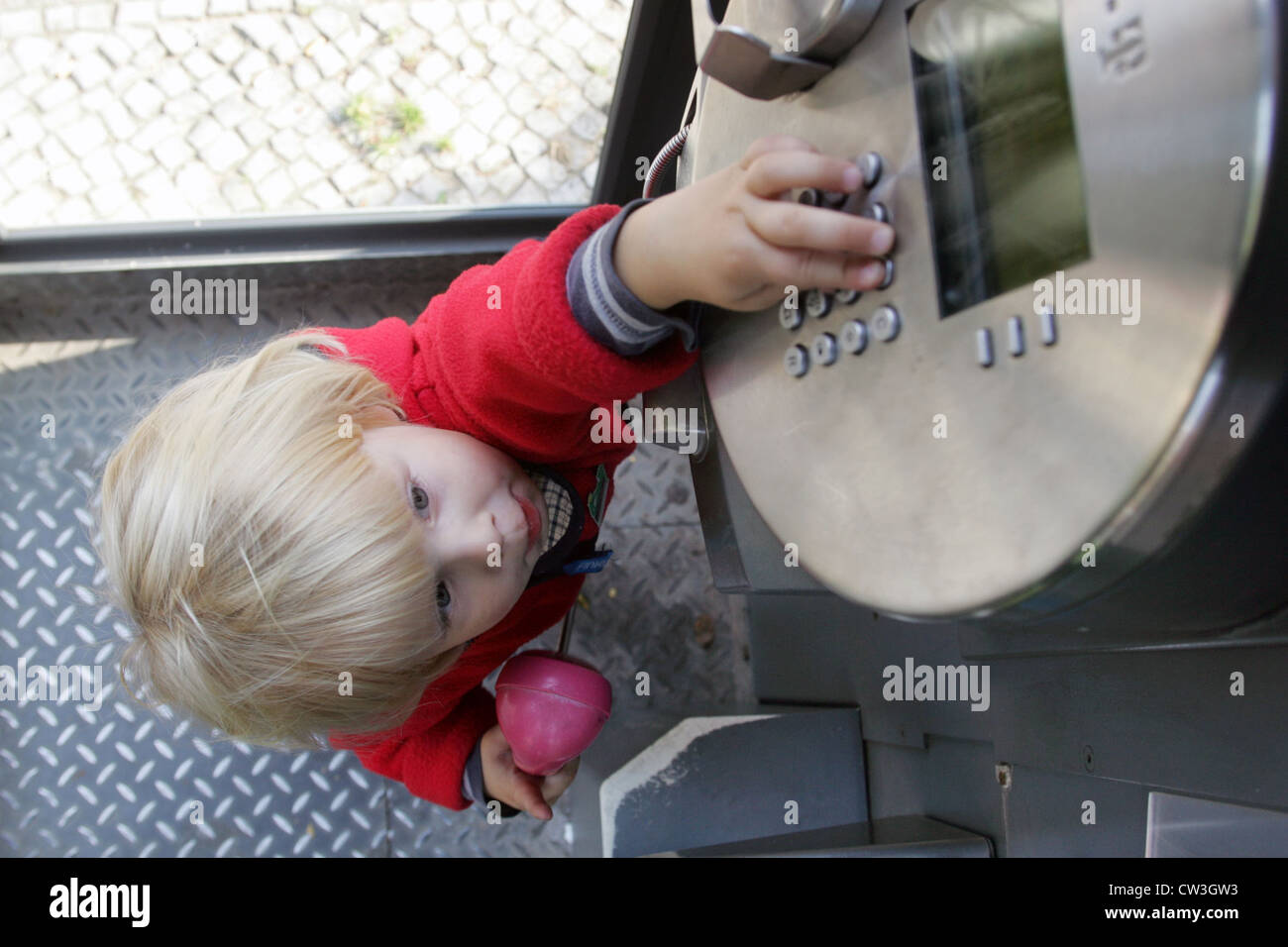 Berlin, ein Kleinkind auf dem Handy in einer Telefonzelle Stockfoto
