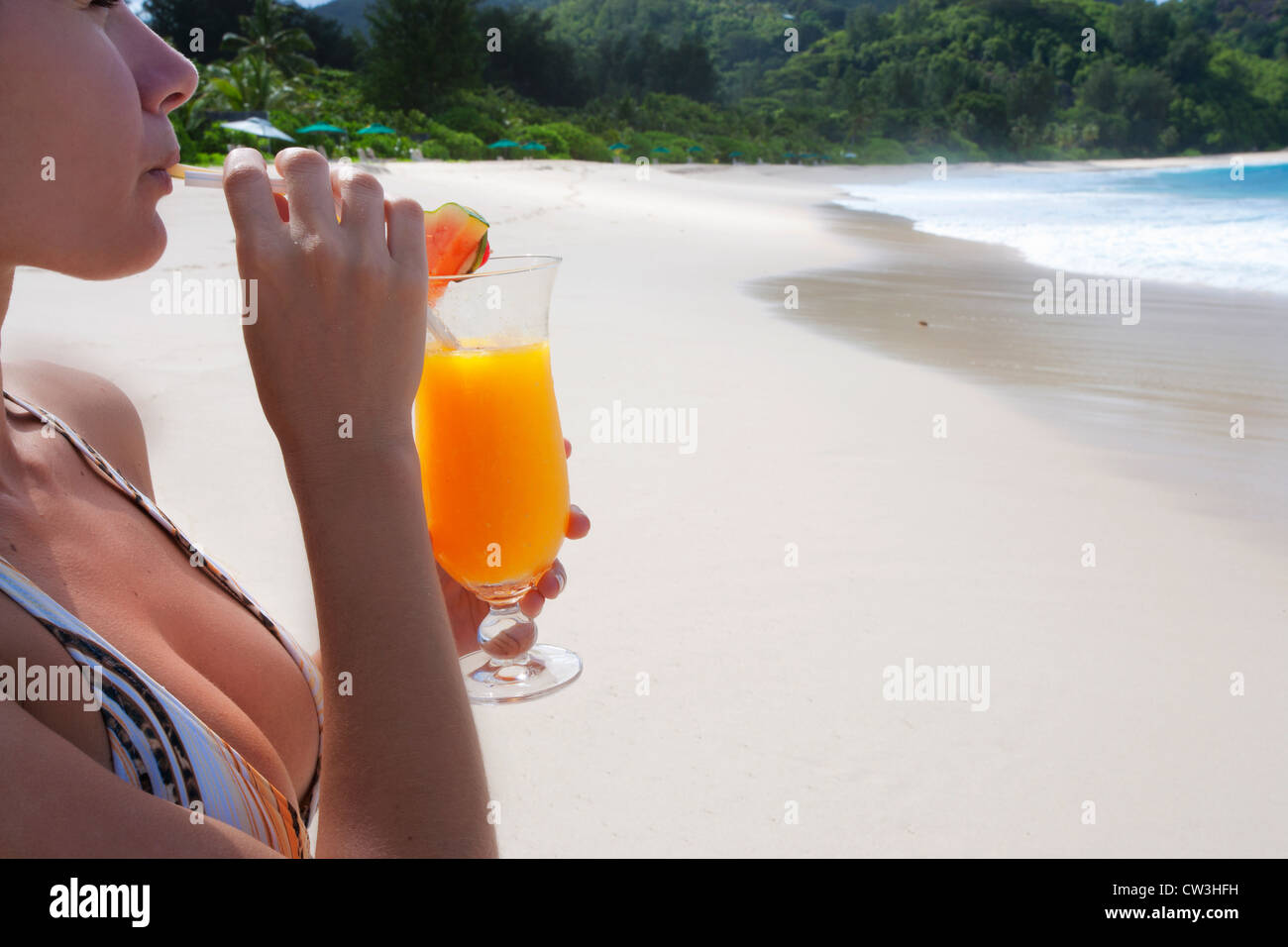 Frau im Badeanzug am Strand einen Cocktail zu trinken. Seychellen Stockfoto