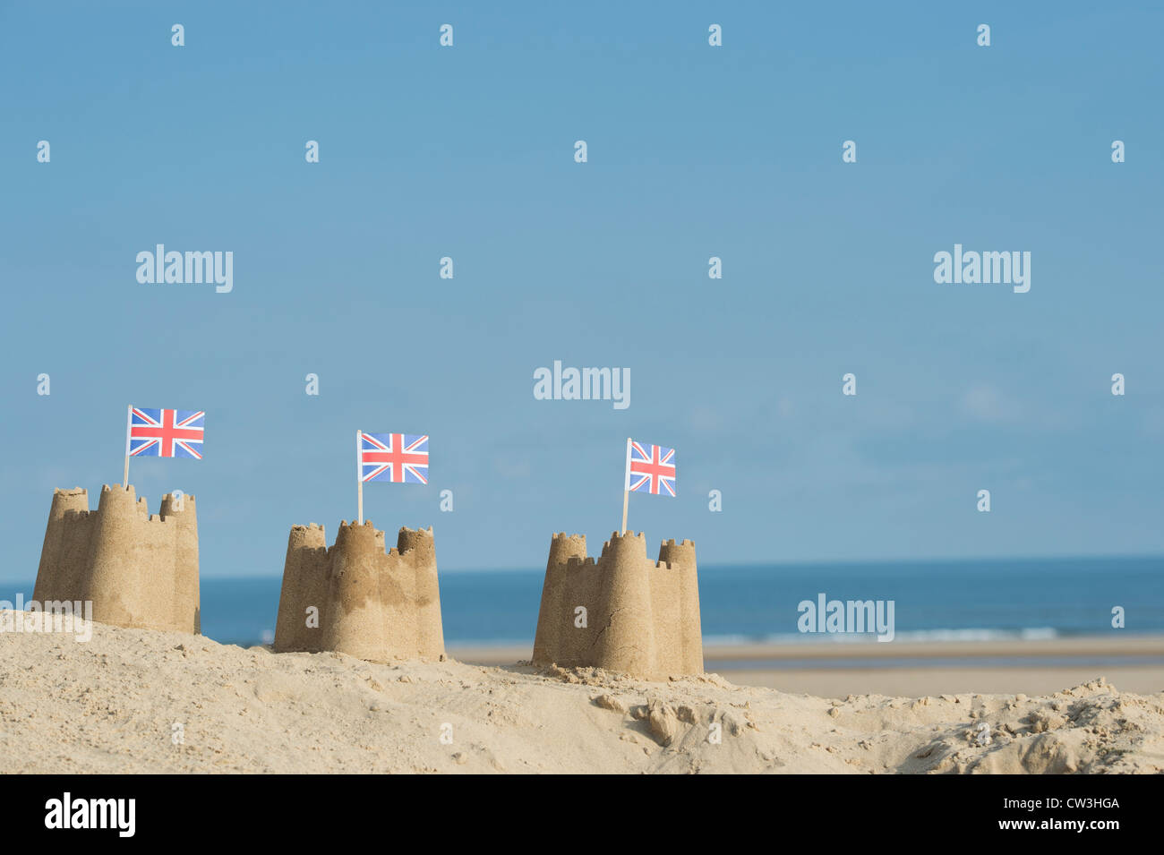 Union Jack-Flaggen in Sandburgen auf einer Sanddüne. Brunnen neben das Meer. Norfolk, England Stockfoto
