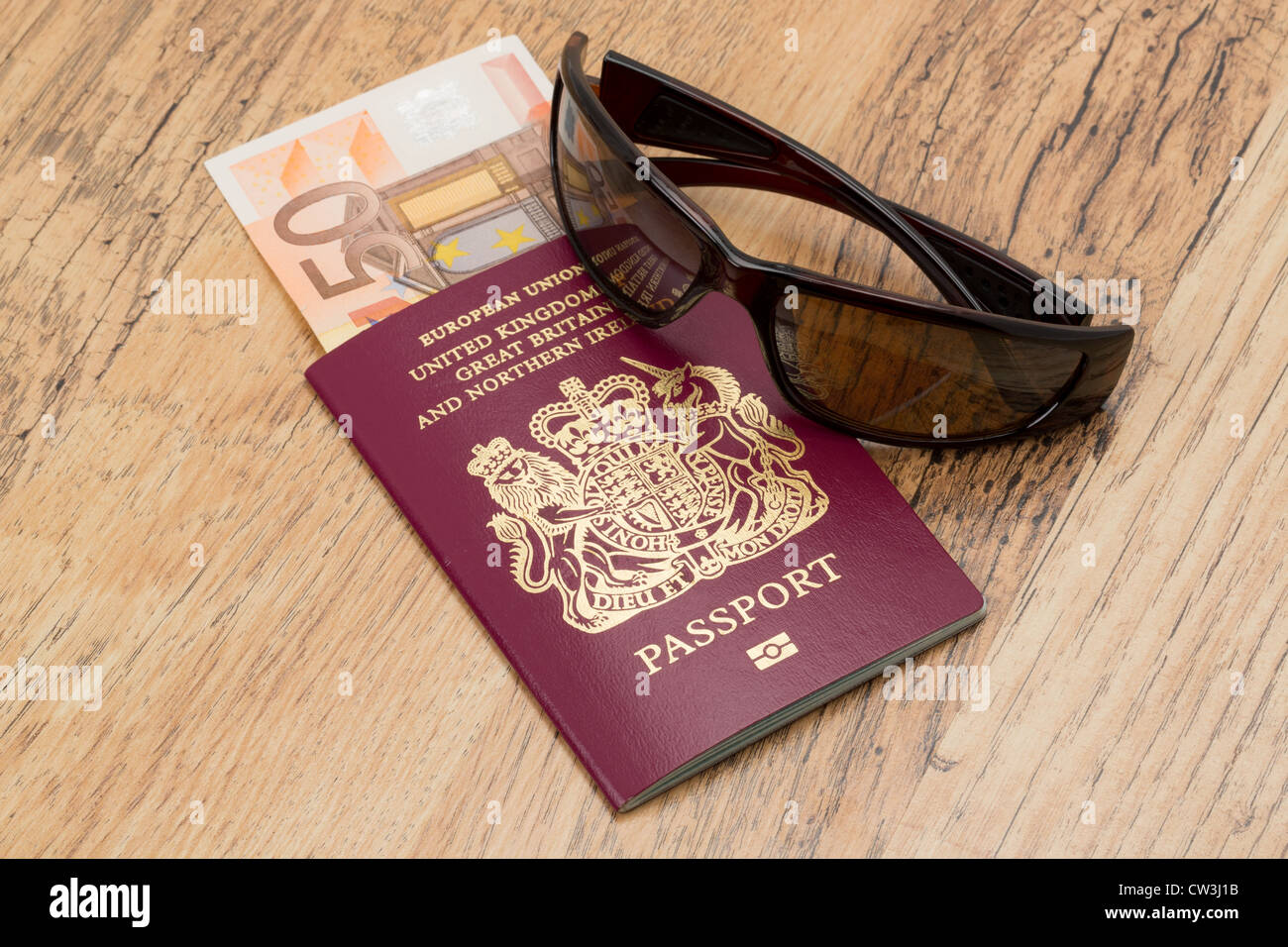 Ein britischen Reisepass mit einigen Euro Geld und coole Sonnenbrillen, platziert auf einem Tisch - Reisen Themen Stockfoto
