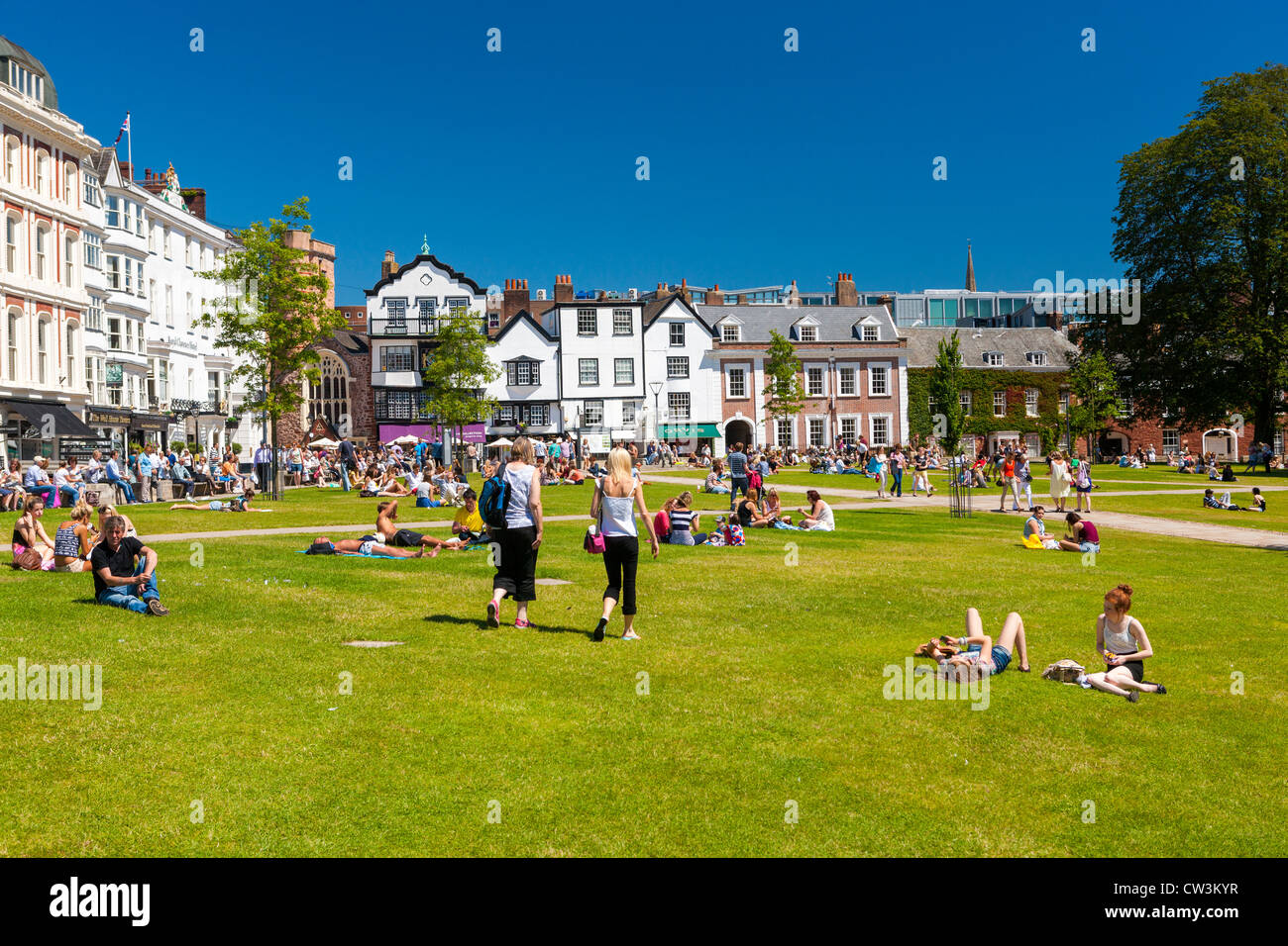 Menschen entspannen auf dem Rasen am Cathedral Close, Exeter, Devon, England Stockfoto