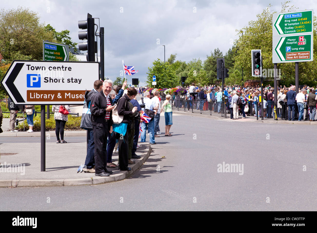 Menschenmengen säumen die Straßen von Walsall, West Midlands, im Laufe der Olympischen Fackel und seines Trägers zu erwarten Stockfoto