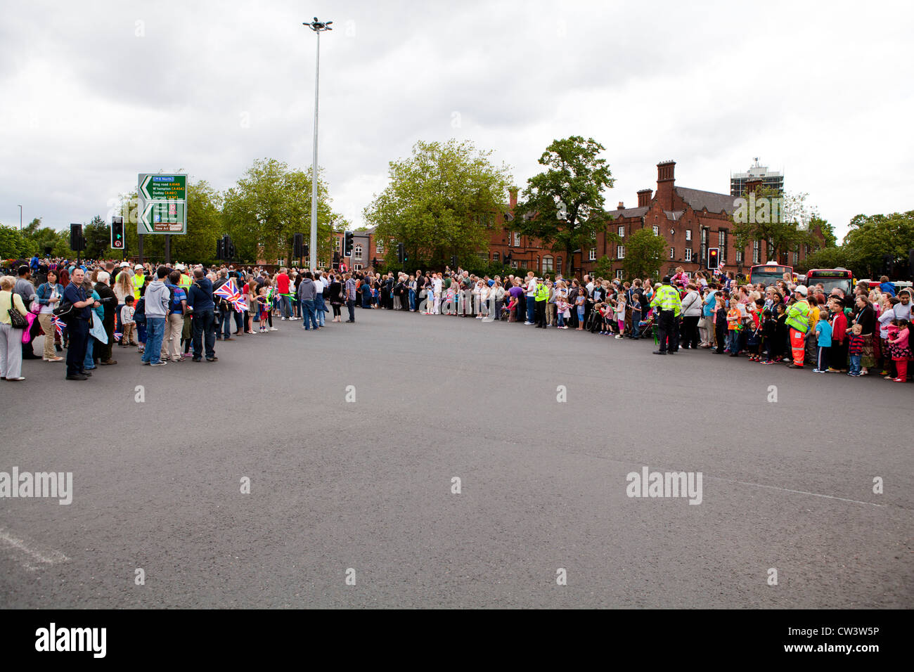 Menschenmengen säumen die Straßen von Walsall, West Midlands, im Laufe der Olympischen Fackel und seines Trägers zu erwarten Stockfoto