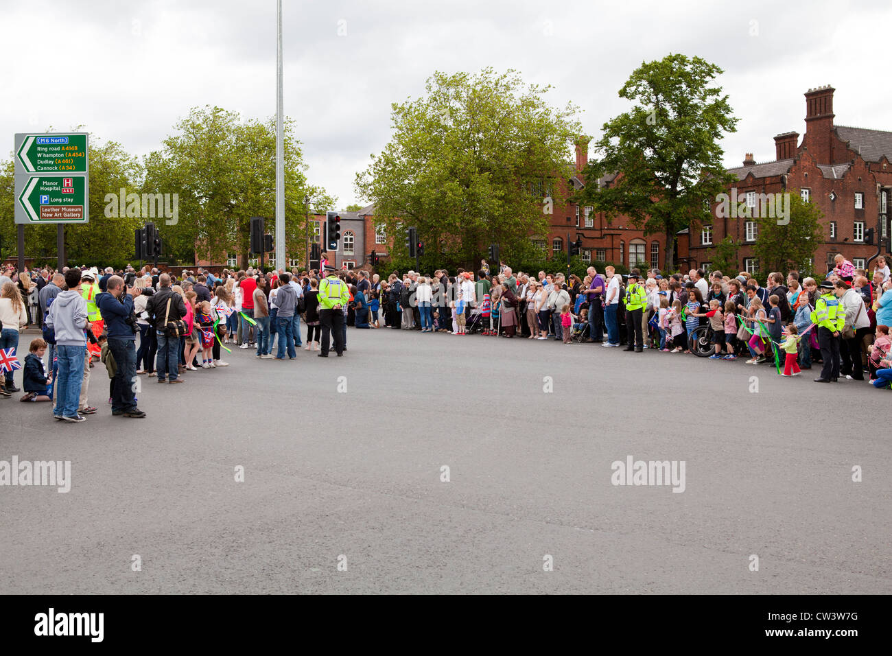 Menschenmengen säumen die Straßen von Walsall, West Midlands, im Laufe der Olympischen Fackel und seines Trägers zu erwarten Stockfoto