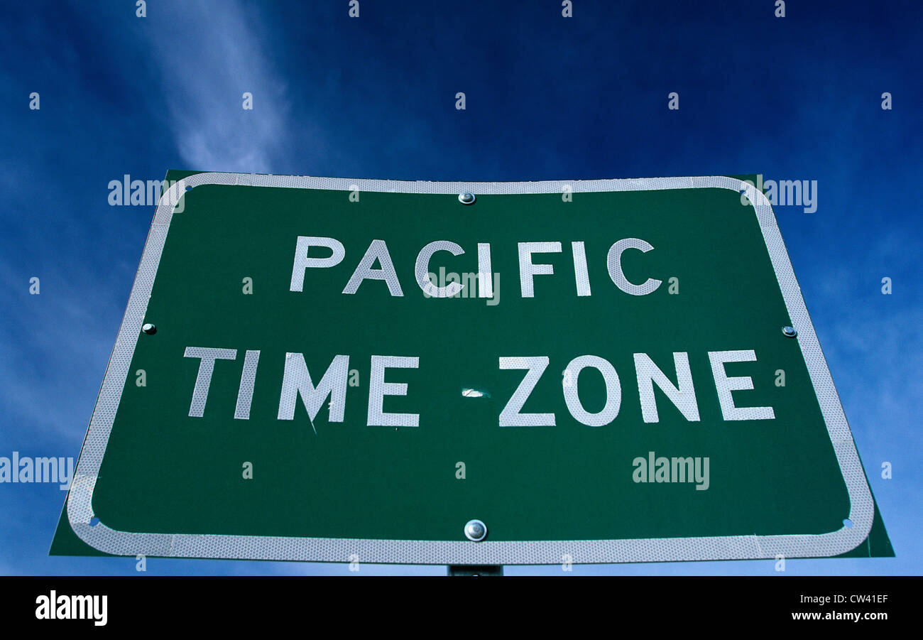 Dies ist ein Schild, das eine Änderung in der pazifischen Zeitzone anzeigt. Die Zeichen ist grün vor einem blauen Himmel. Stockfoto