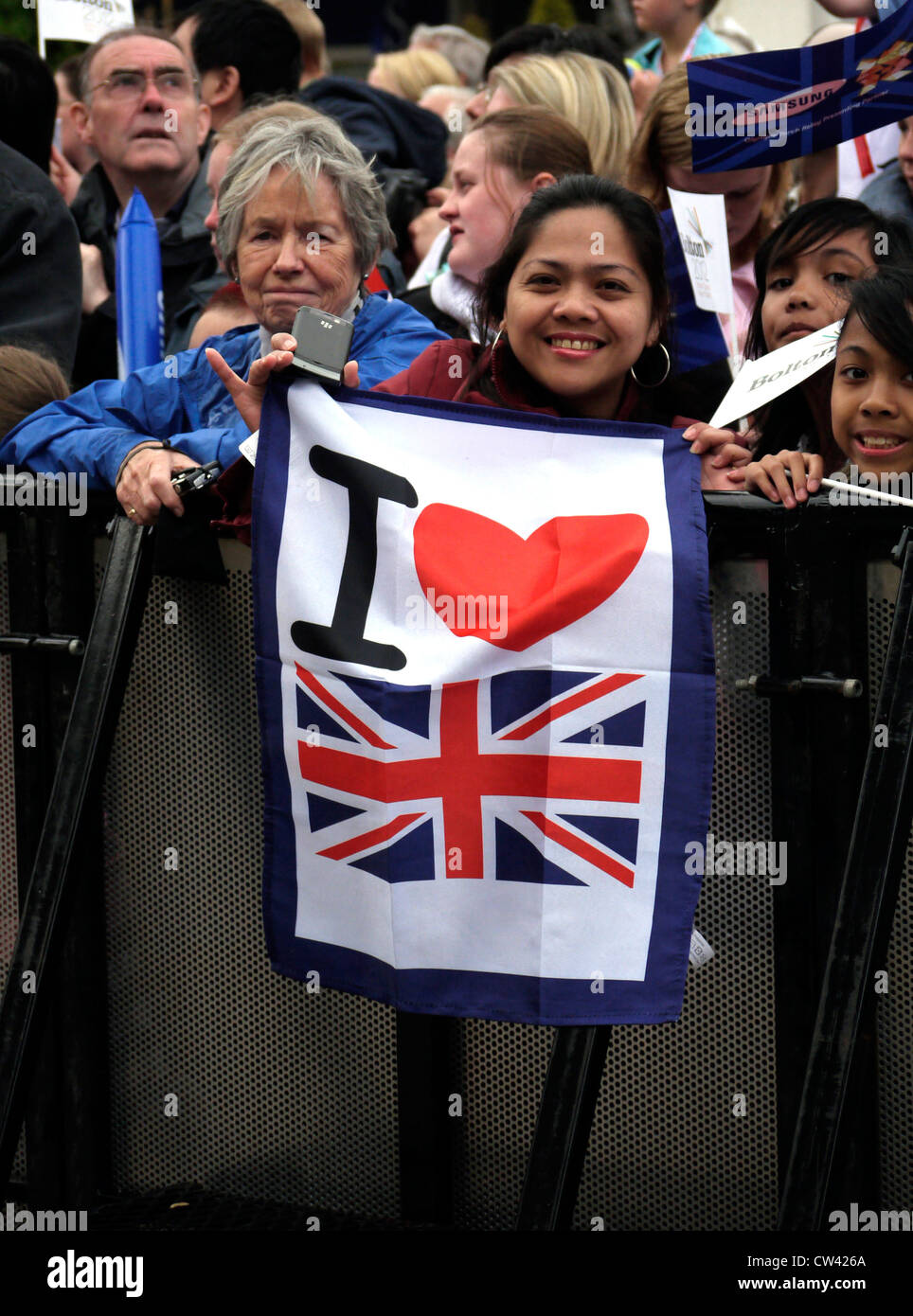 Asiatische Frau Holding "Ich liebe GB" Banner an einer großen Parade in Großbritannien Stockfoto
