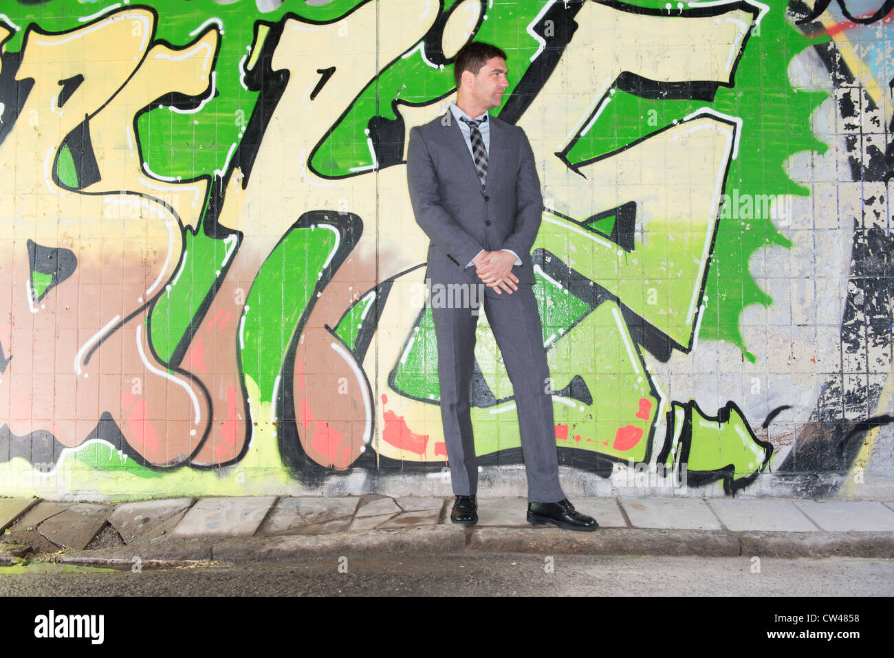 Geschäftsmann vor Wand bedeckt mit Graffiti Stockfoto