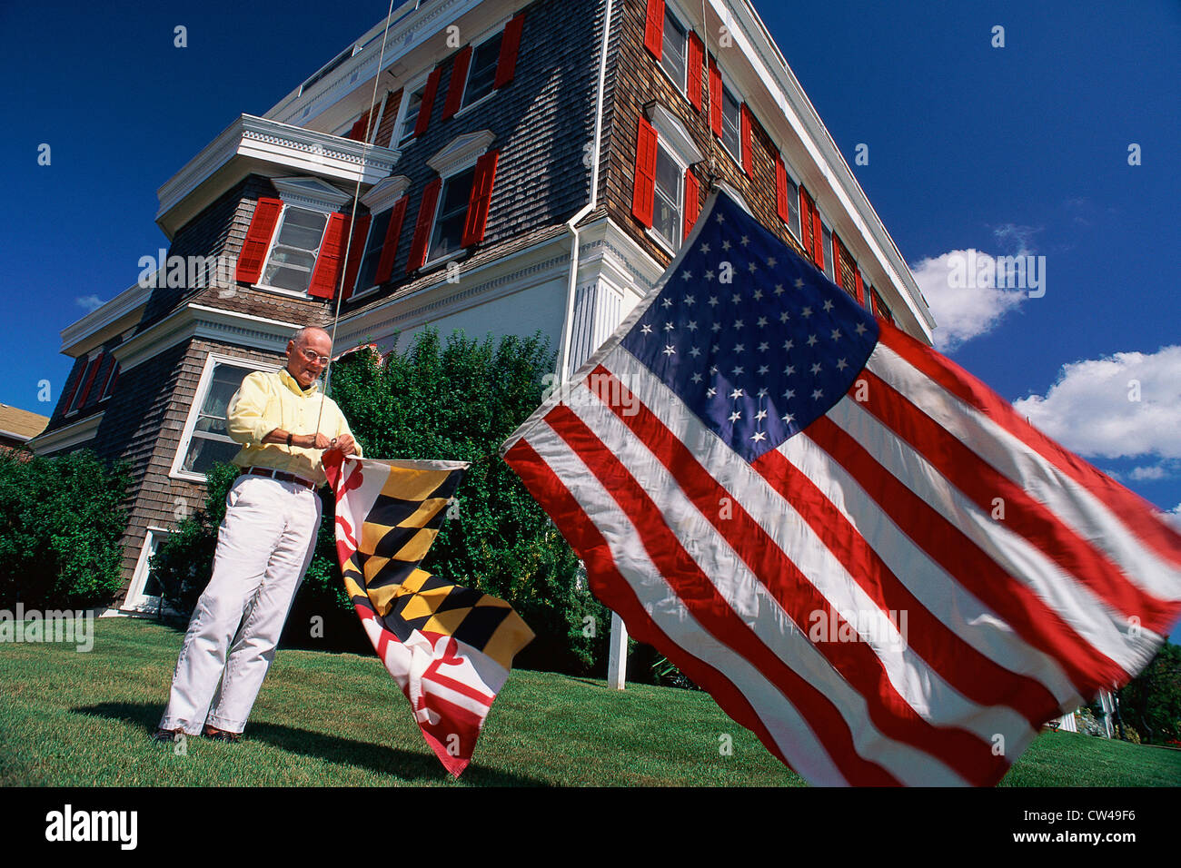 Älterer Mann hängen, amerikanischen und Zustandsflags Stockfoto