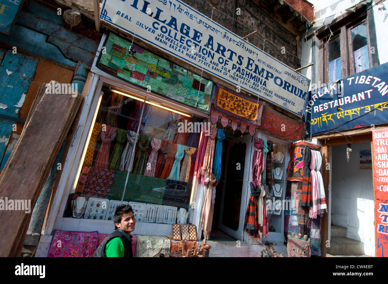 Junger Mann außerhalb Dorf Arts Emporium, einem Shop, Verkauf von Schmuck und Schals, im Zentrum von Leh, Ladakh, Indien Stockfoto
