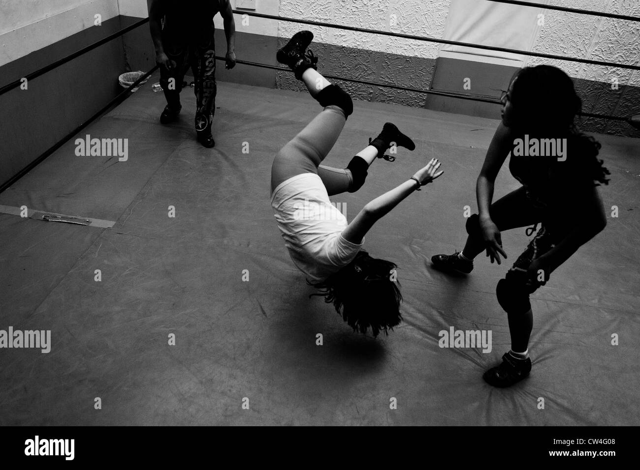 Ein weibliche Lucha Libre Wrestler wirft ihr Sparringspartner während der Schulungen in einer Sporthalle in Mexiko-Stadt. Stockfoto