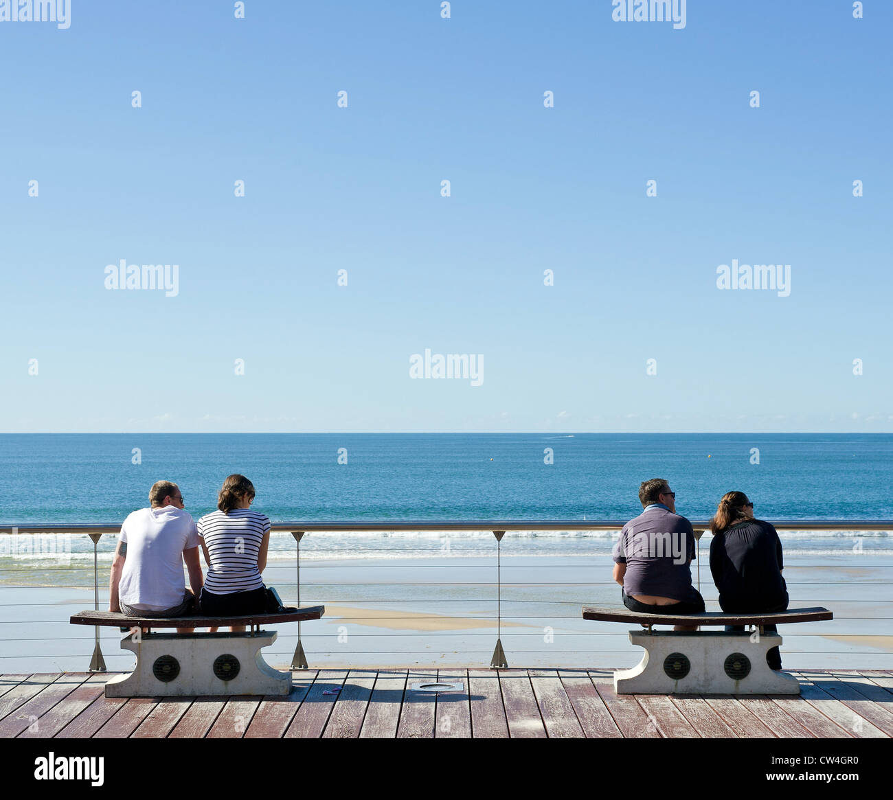 Zwei Paare sitzen auf Bänken an der Strandpromenade von Mooloolaba an der Sunshine Coast in Queensland Stockfoto