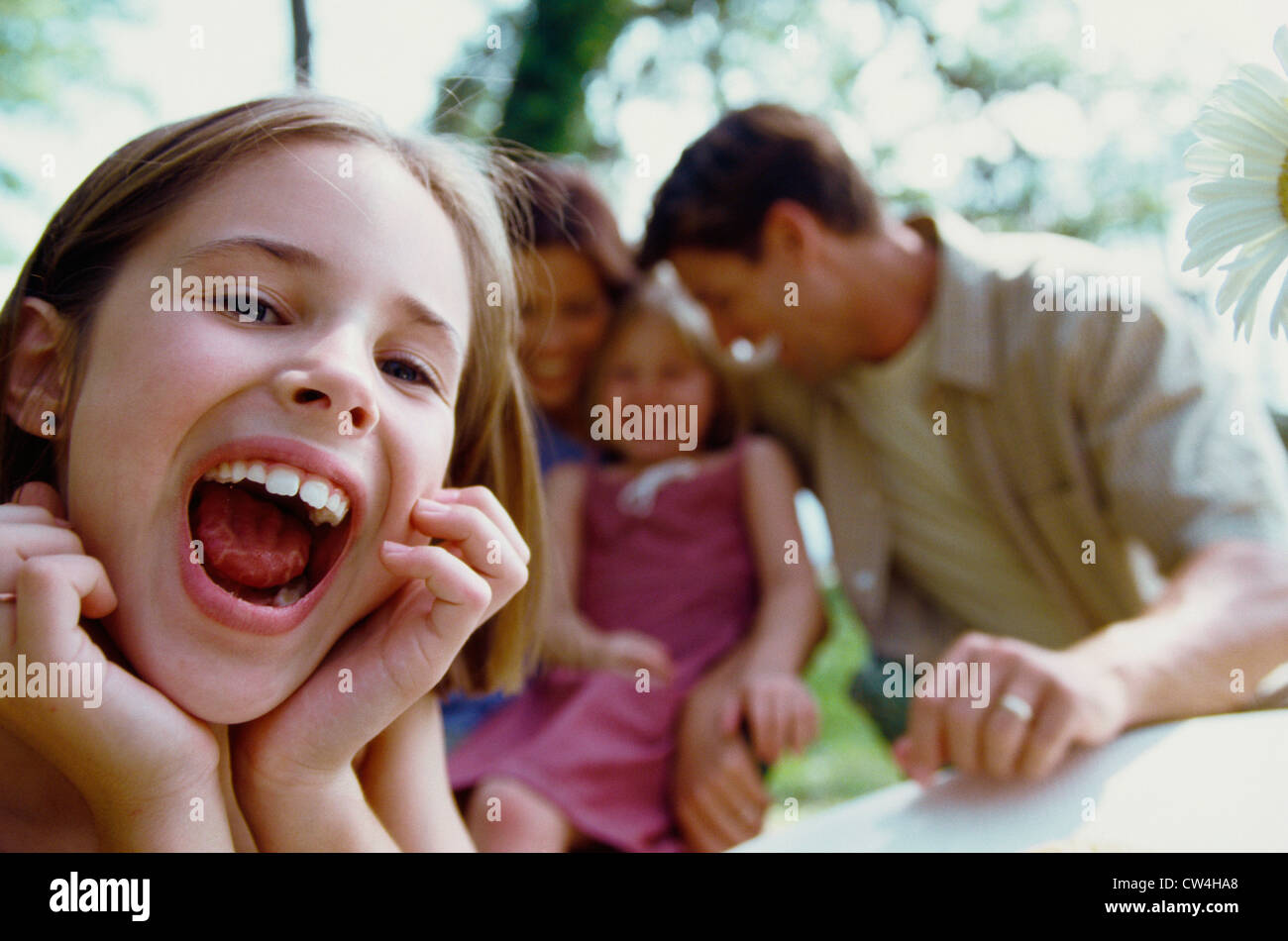 Porträt eines Mädchens mit ihren Eltern und ihrer Schwester sitzt hinter ihr Lachen Stockfoto