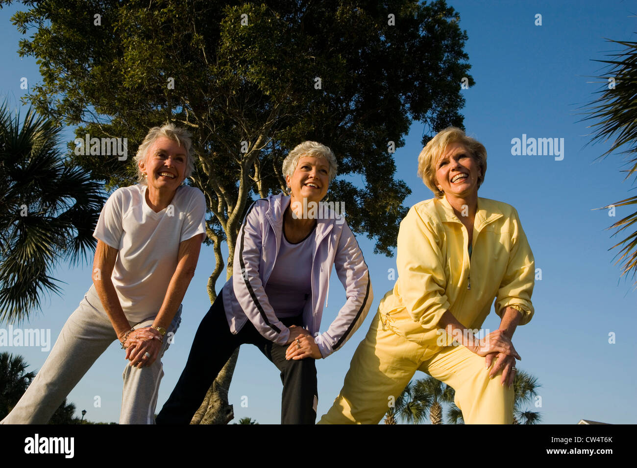 Fröhlichen Frauen in Führungspositionen mit Hand am Knie trainieren Stockfoto