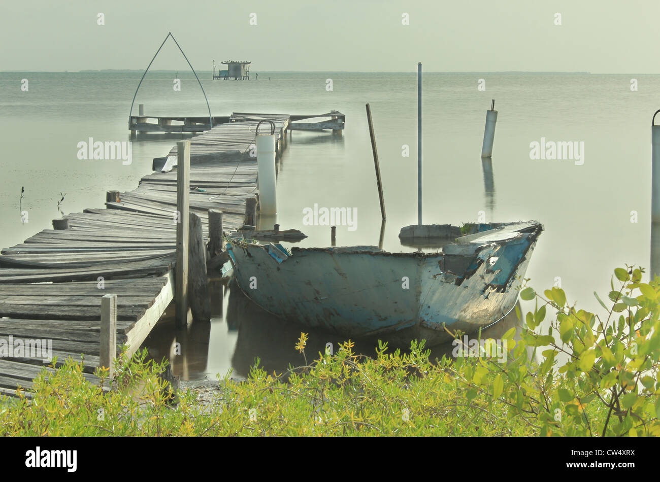 Tag mit Dock zu beruhigen und Boot in Ruinen auf Karibik auf Caye Caulker, Belize Stockfoto