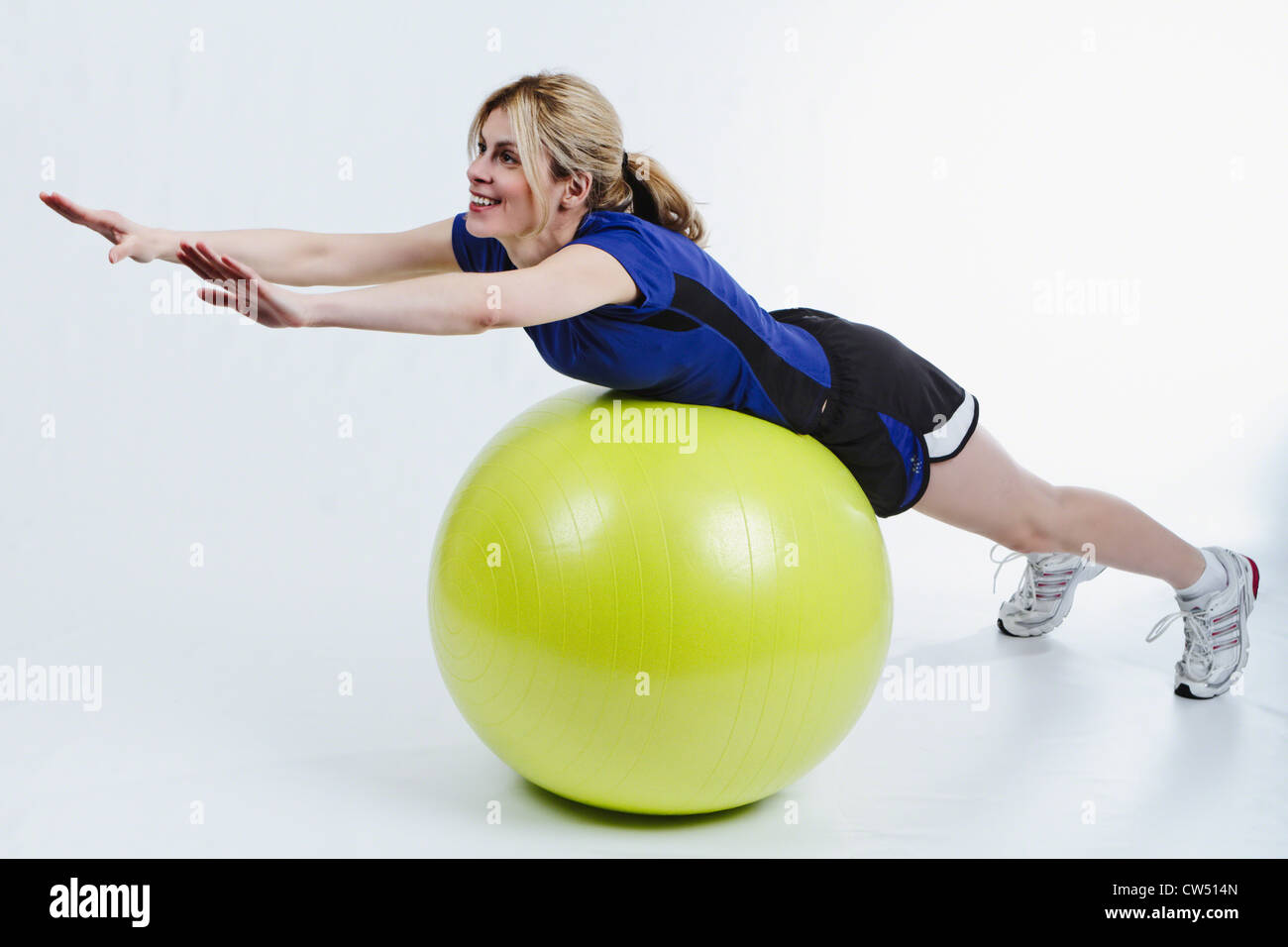 Frau liegend auf Bauch auf Gymnastikball und Stretching Stockfoto