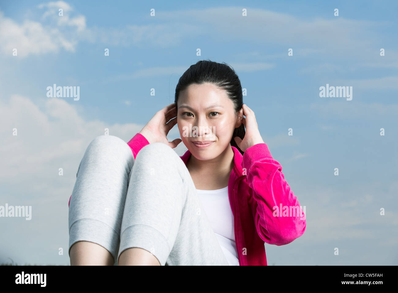 Chinesische Frau tun Sit ups im Park. Stockfoto