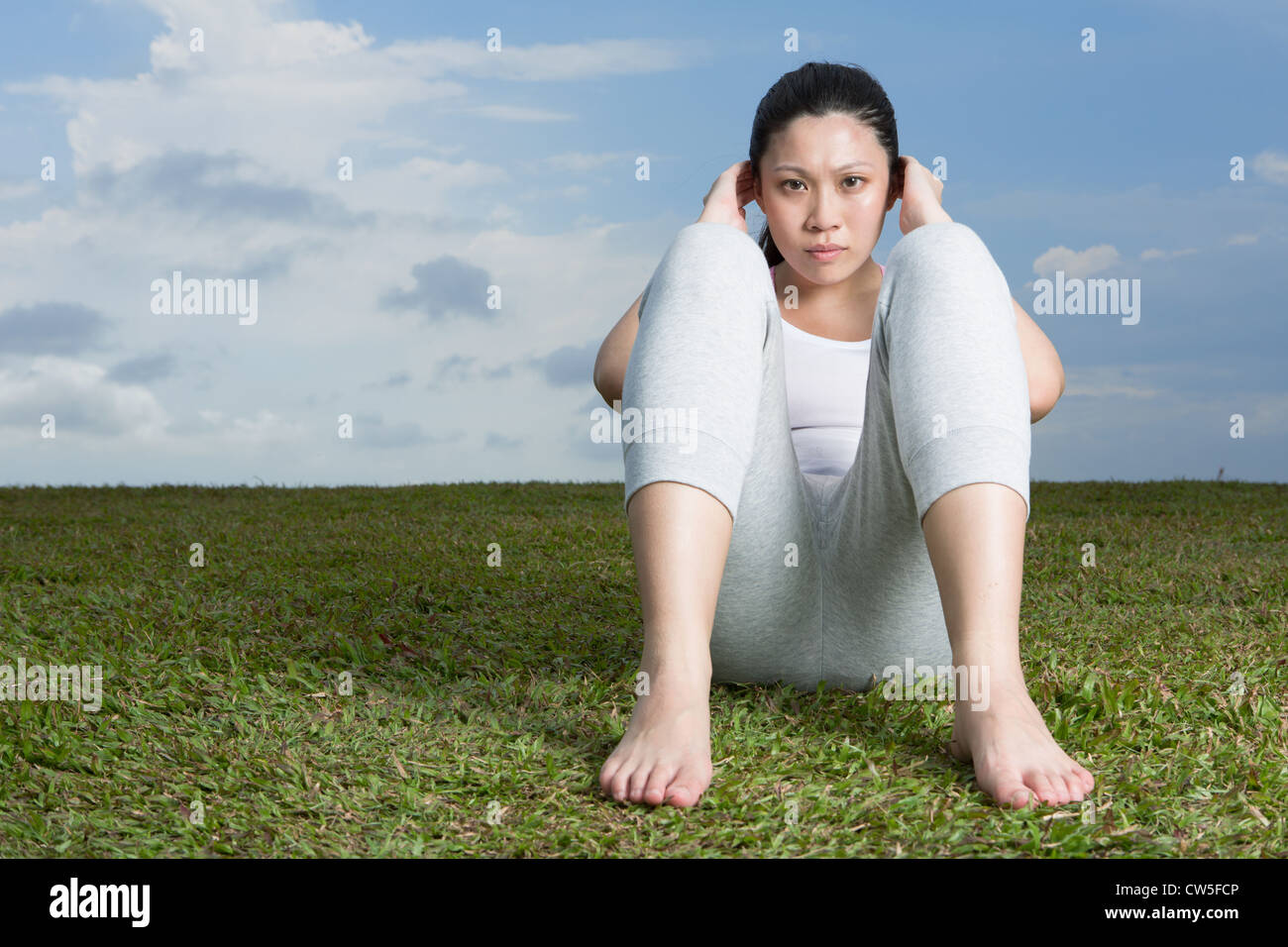 Chinesische Frau tun Sit ups im Park. Stockfoto