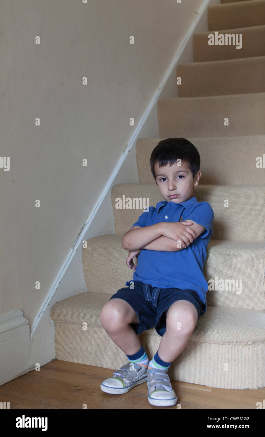 Junge, 5 Jahre alt, sitzt auf der Treppe Stockfoto