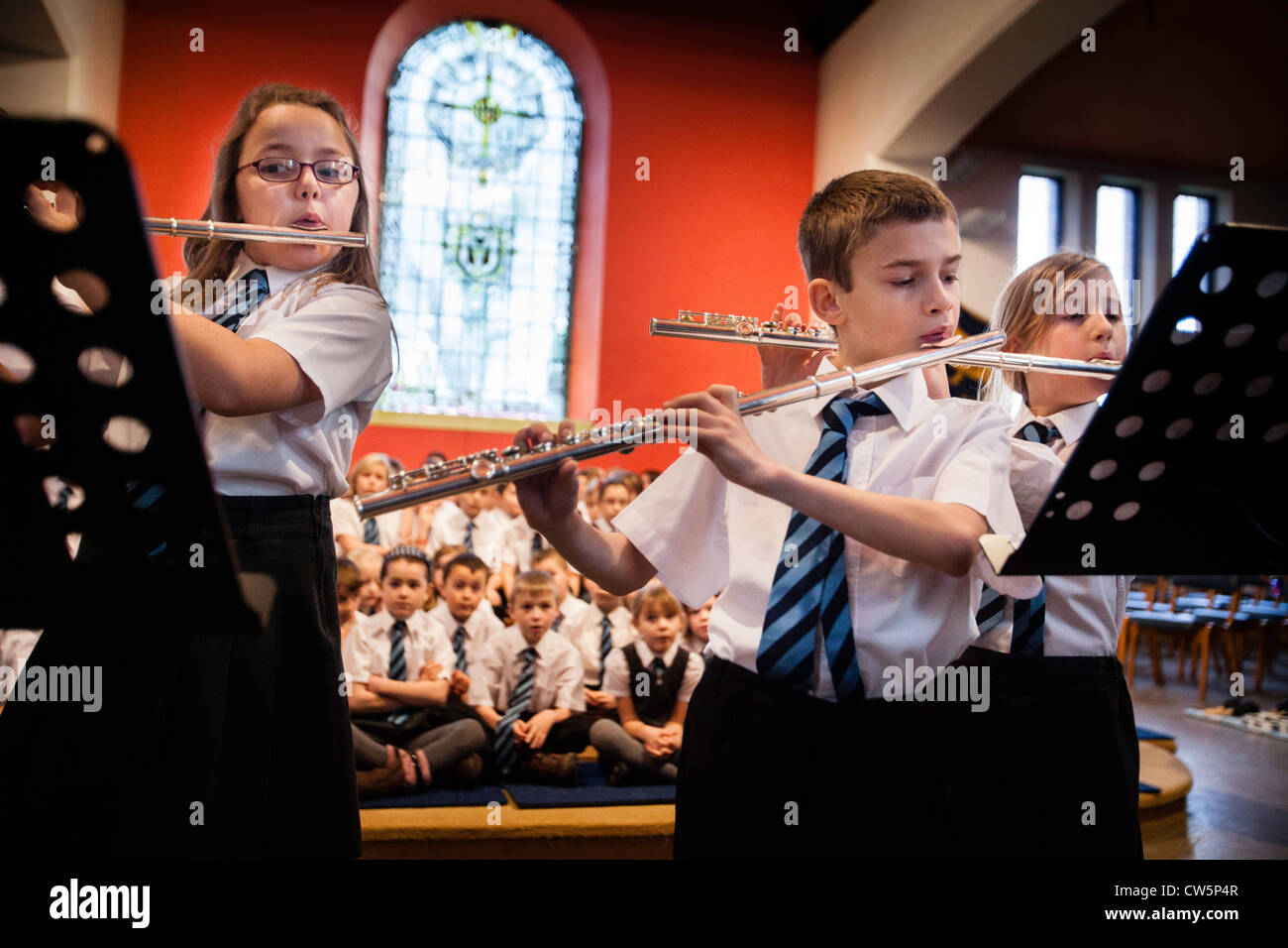 Schülerinnen und Schüler in Oakridge Grundschule in Staffordshire, UK, spielen in einem Konzert bei ihrer Ortskirche. Stockfoto