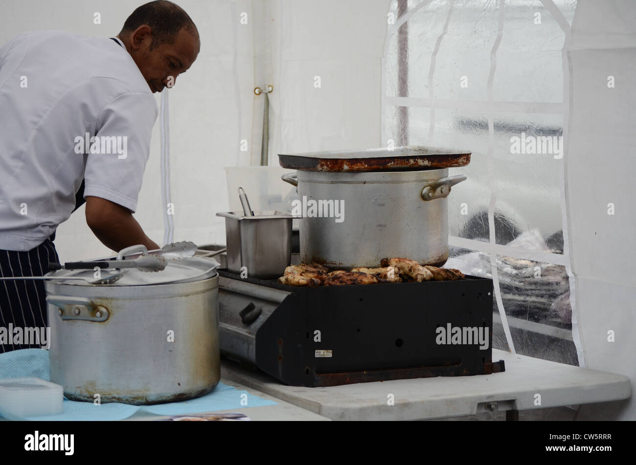 Koch, Afro-Karibischen Zubereitung auf einem Marktstand Stockfoto