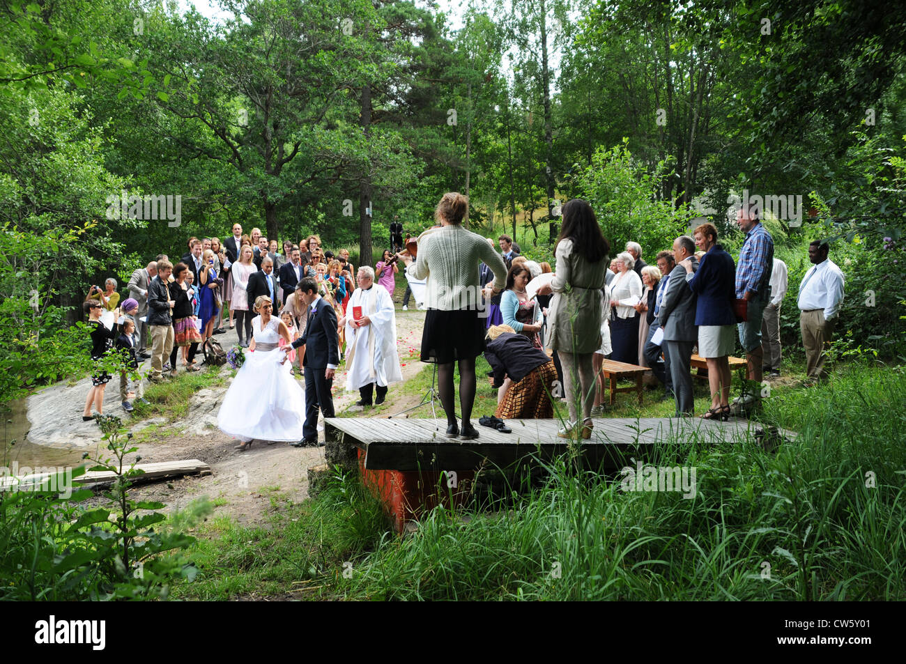 Hochzeitszeremonien mit Braut und Bräutigam und Priester am Ufer des Sees oder Ostsee in Schweden Stockfoto