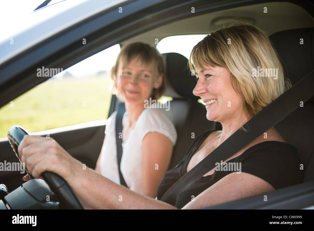 Lächelnde senior Frau Autofahren mit ihrem Erwachsenen Kind Stockfoto