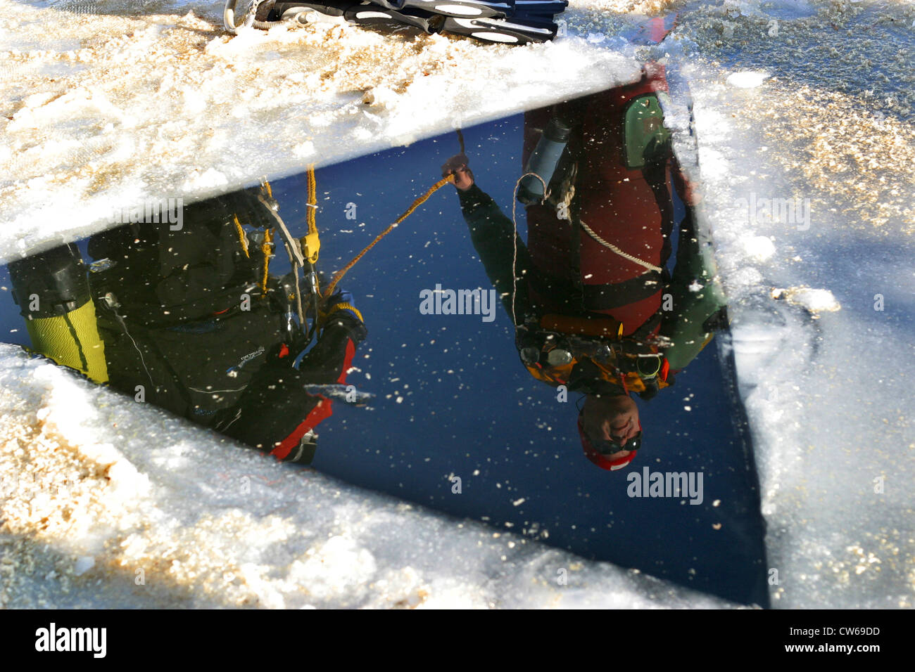 Dreieck Loch im gefrorenen See, Eis-Taucher, die Spiegelung auf der Wasseroberfläche, Euskirchen, Nordrhein-Westfalen, Deutschland und Steinbach-Talsperre Stockfoto