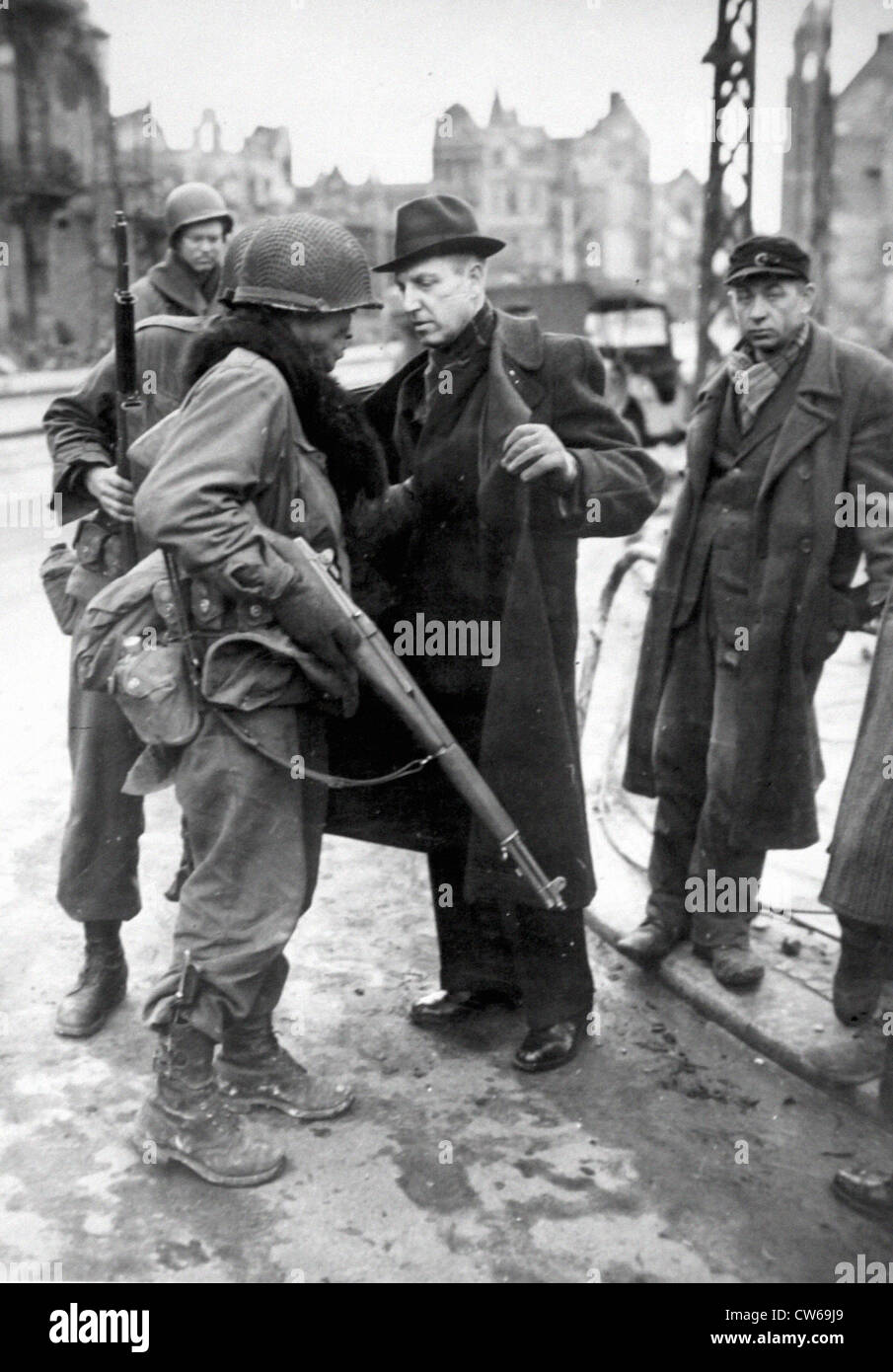 Ein US-Soldat sucht deutsche Zivilisten in Krefeld (Deutschland) am März 1945 Stockfoto