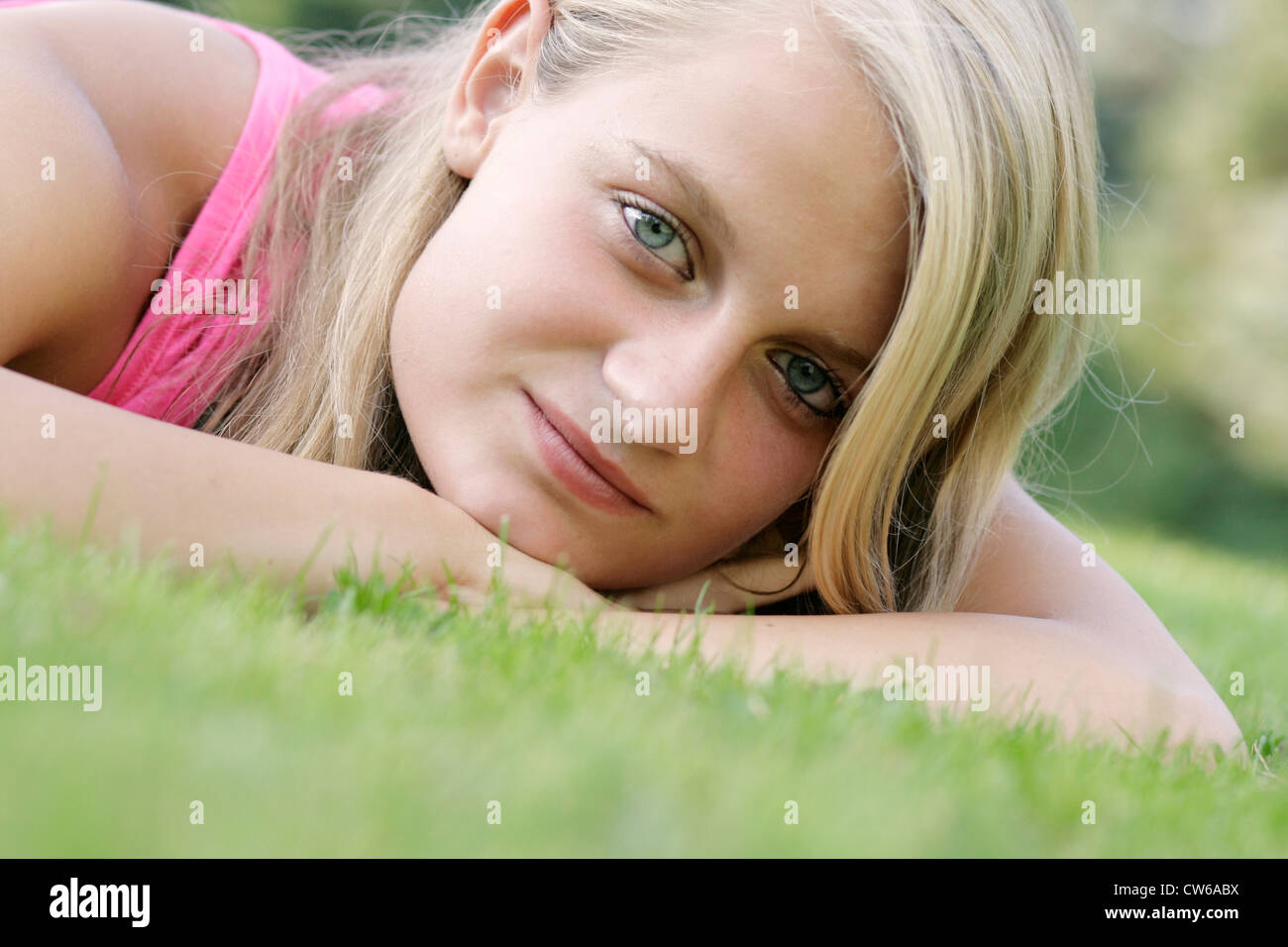 junge blonde Mädchen auf einer Wiese liegend Stockfoto