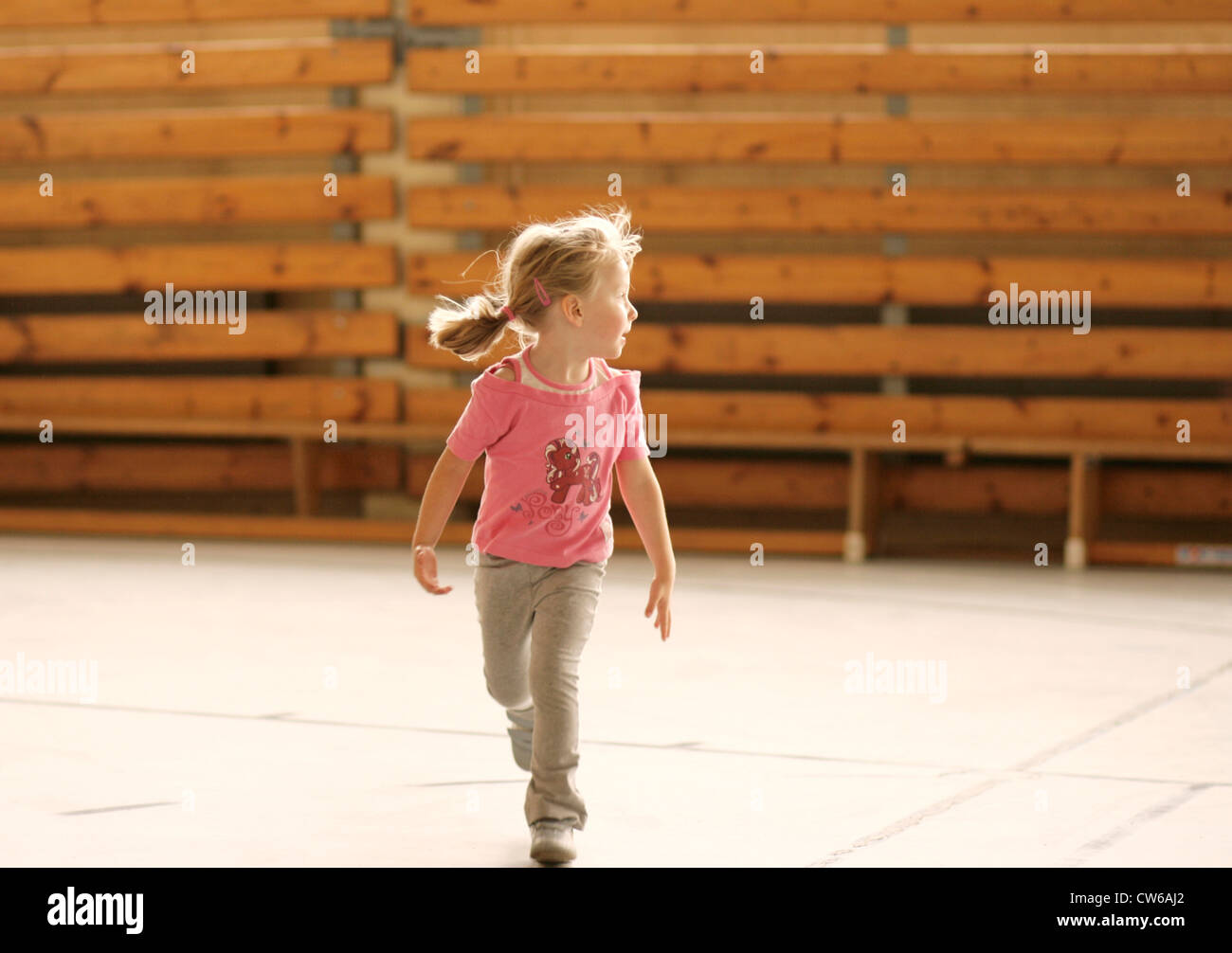 kleine Mädchen laufen in einer Sporthalle Stockfoto