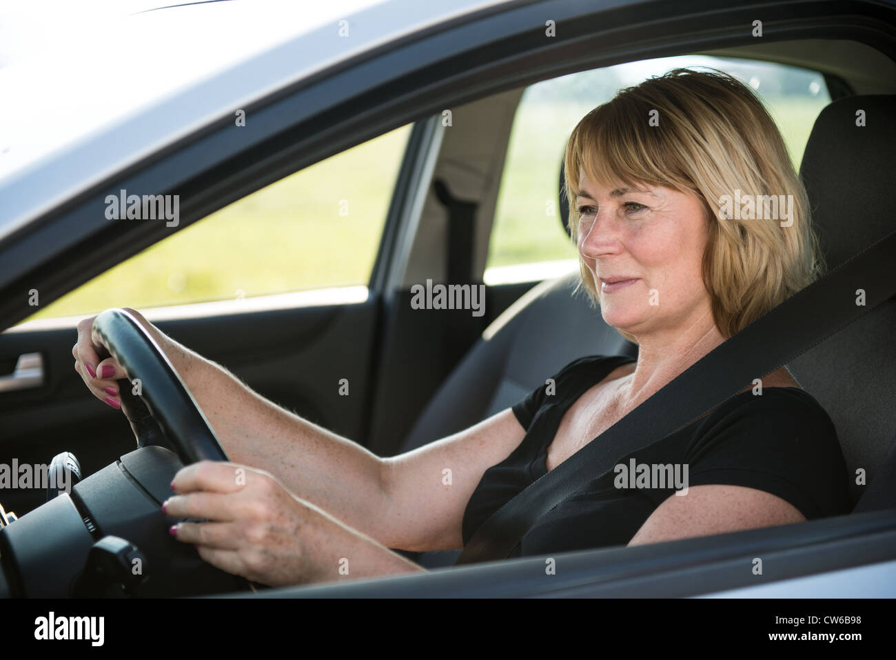 Porträt von attraktiven senior lächelnde Frau sitzen im Auto Stockfoto