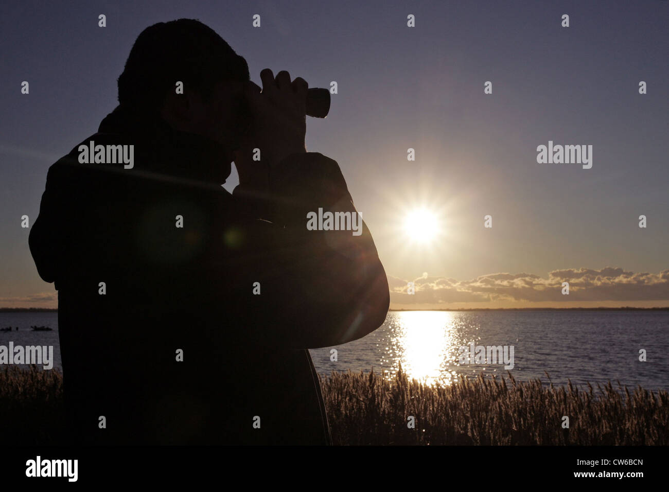 Zingst Mann schaut durch sein Fernglas Stockfoto