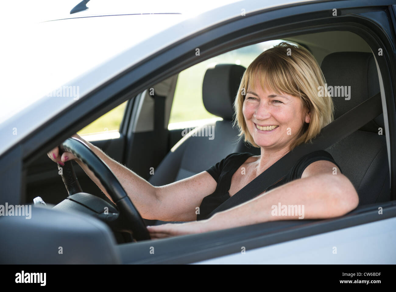 Porträt von attraktiven senior lächelnde Frau sitzen im Auto Stockfoto