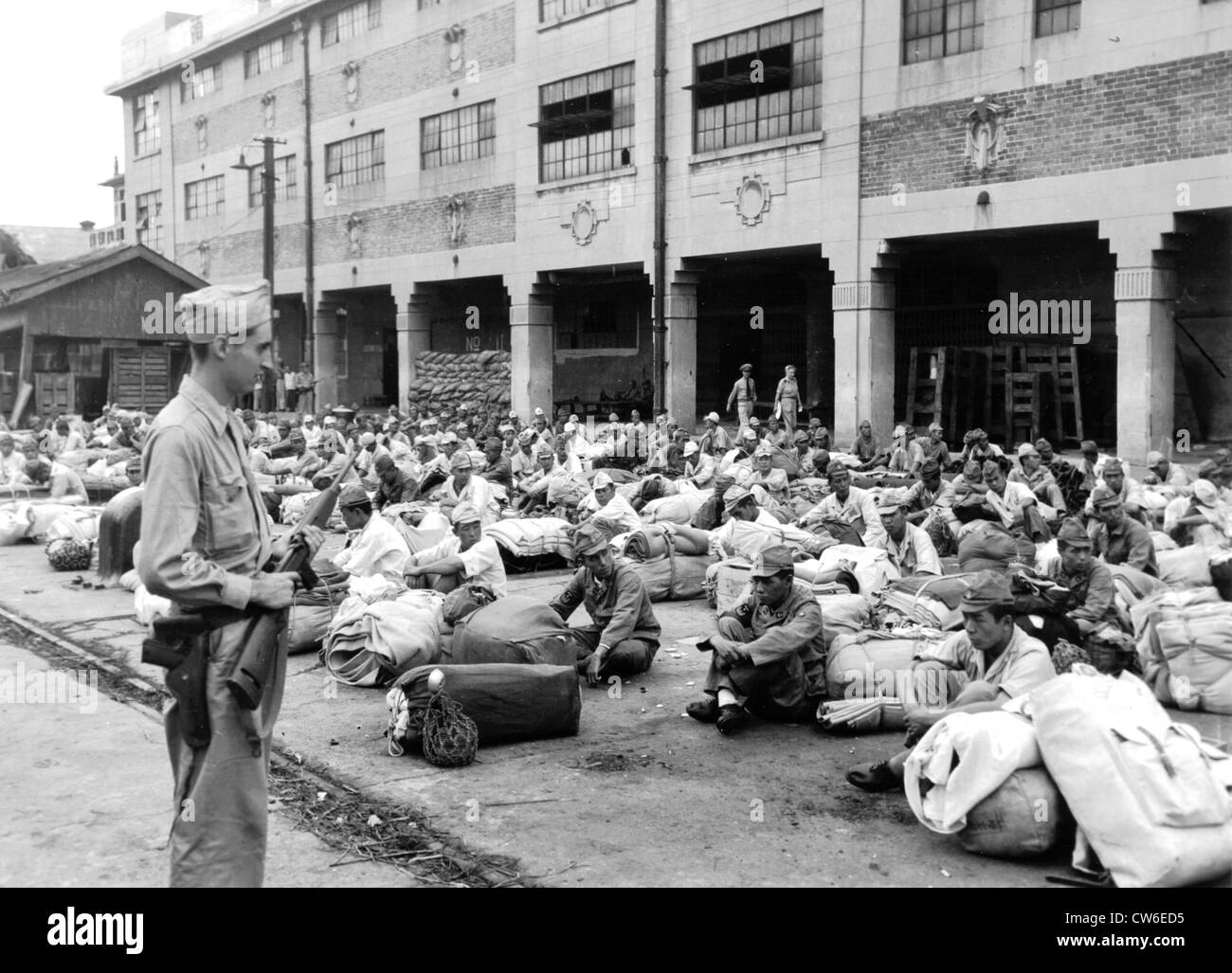 Japanische Soldaten bewacht von einem amerikanischen Soldaten in Shanghai, 28. September 1945 Stockfoto