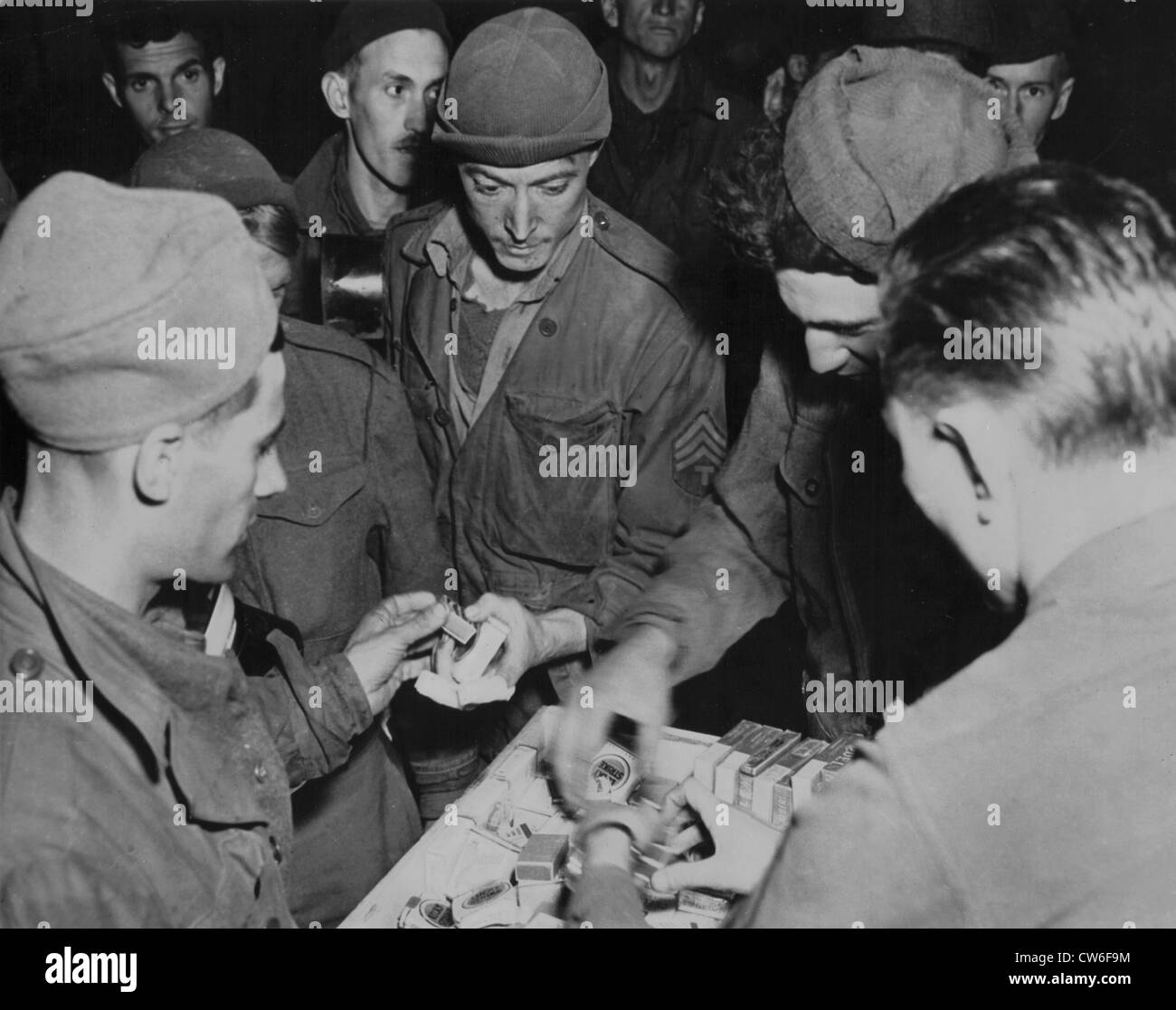 Maskierte US Gefangenen erhalten erste amerikanische Zigaretten, April 1945 Stockfoto