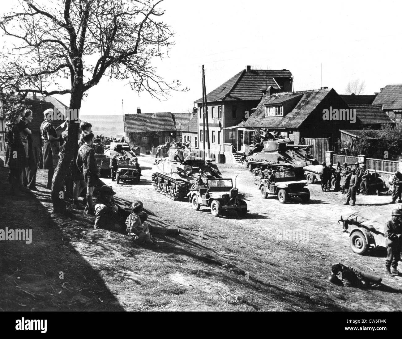 Deutsche Zivilisten sehen 9. US-Armee Truppen während ihrer Fahrt an Elbe (April 1945) Stockfoto