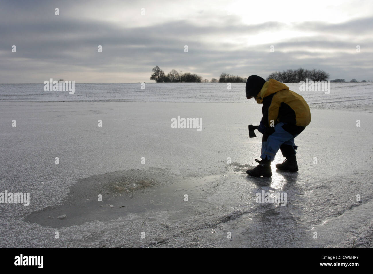Strahlende Dorf Kind schlägt ein Loch in einem zugefrorenen See Stockfoto