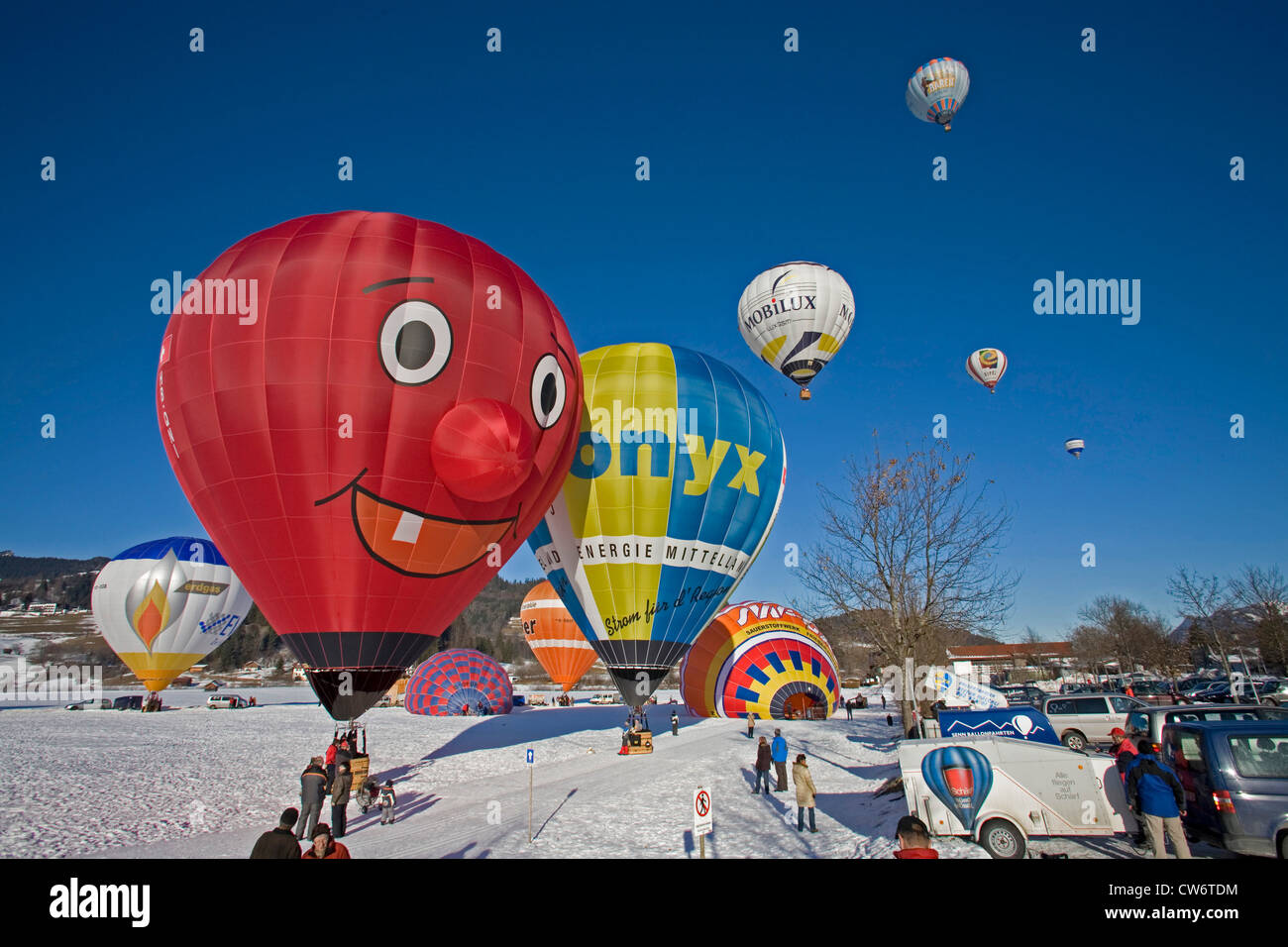 Heißluft-Ballon-Festival auf einem Schneefeld mit mehreren Ballons in Vorbereitung für den Start oder abgenommen haben und eine Menge von Zuschauern, Oberstdorf, Allgäu, Bayern, Deutschland Stockfoto