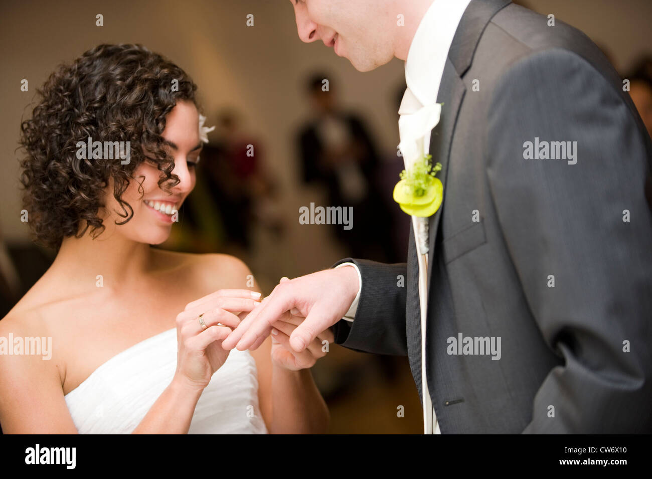 eine standesamtliche Trauung, Braut, kleben den Ehering am Finger ihres Ehemannes heiratete Stockfoto