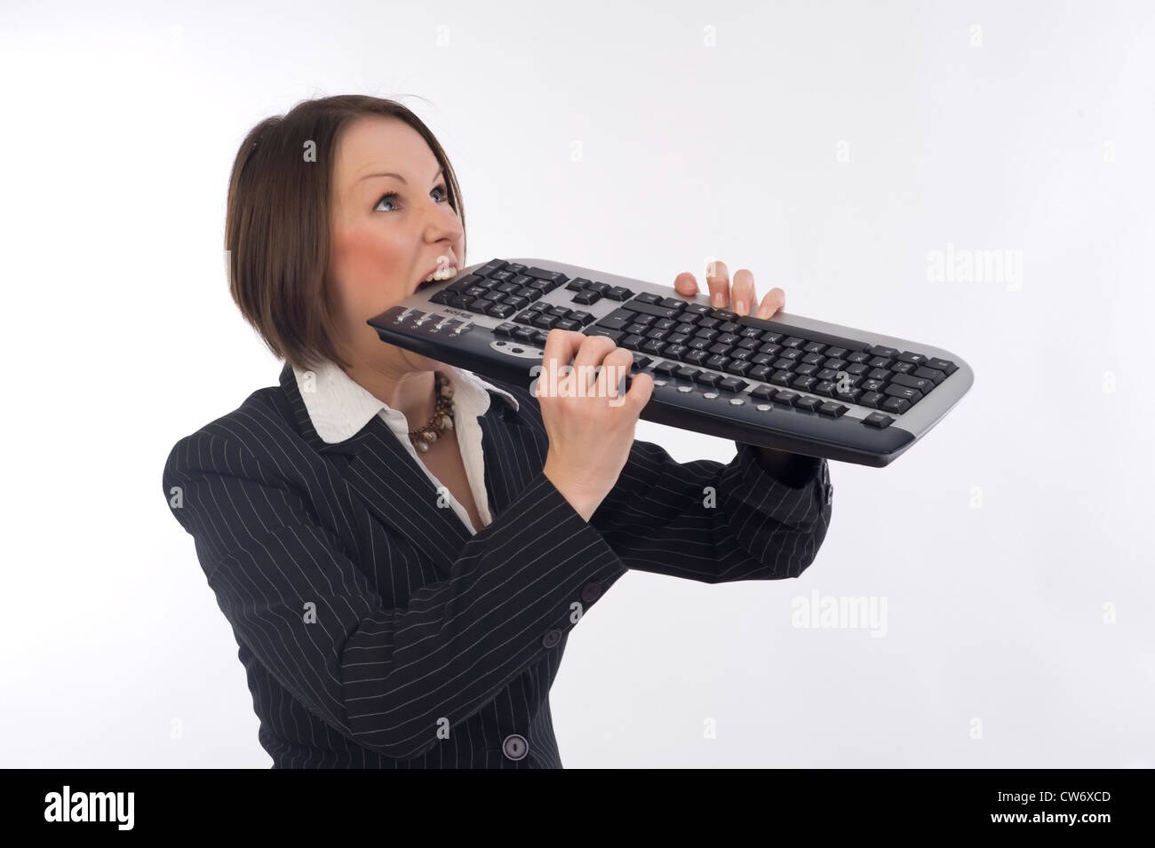 Business Frau beißt in Tastatur Stockfoto