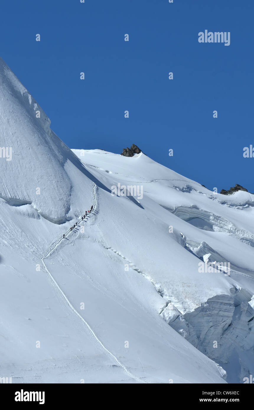 Team von nicht identifizierten Kletterer Klettern steilen Hang, Seilschaft über eine riesige Gletscherspalte, in einwandfreiem Zustand Stockfoto