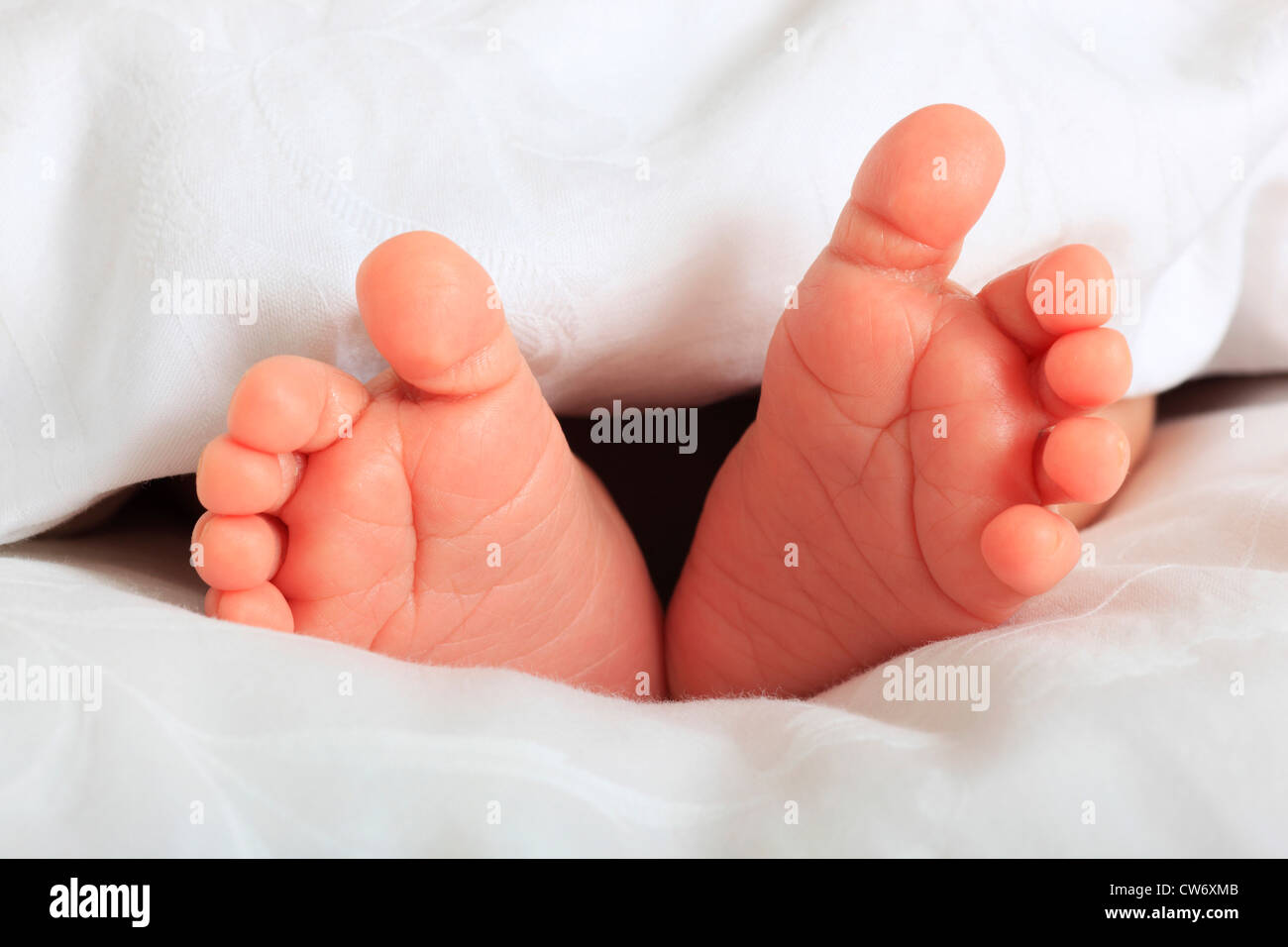 ein Baby Füße unter die Decke herausragen Stockfoto