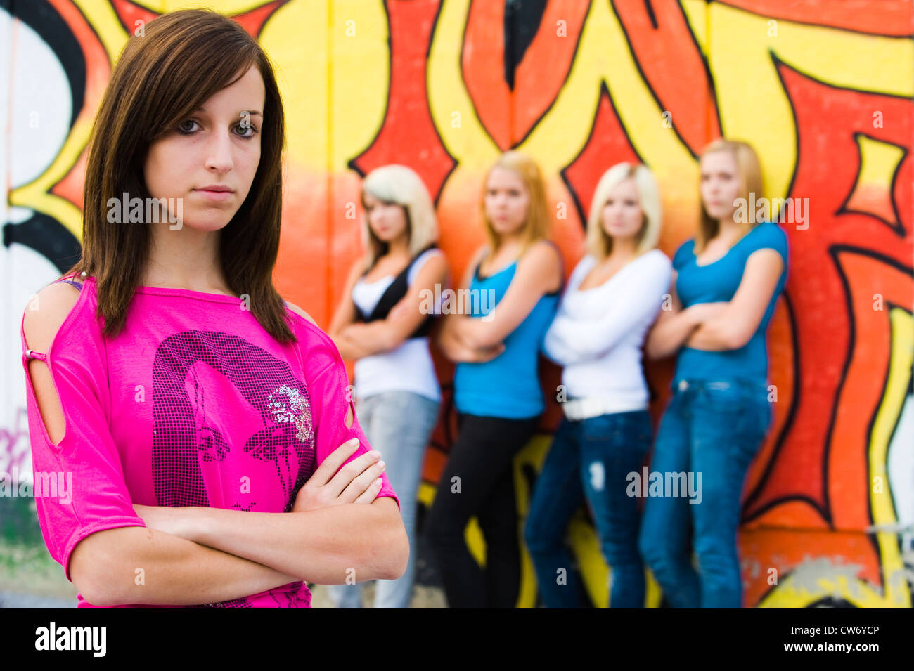 fünf SchülerInnen posiert auf dem Schulhof vor einer Graffitiwand Stockfoto