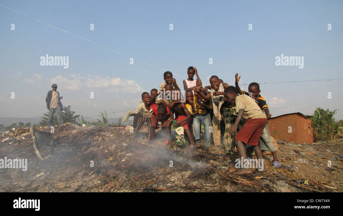 Kinder posiert auf einer Deponie in den Slums hinter brennenden Müll, Burundi, Bujumbura Mairie, Buyenzi, Bujumbura Stockfoto